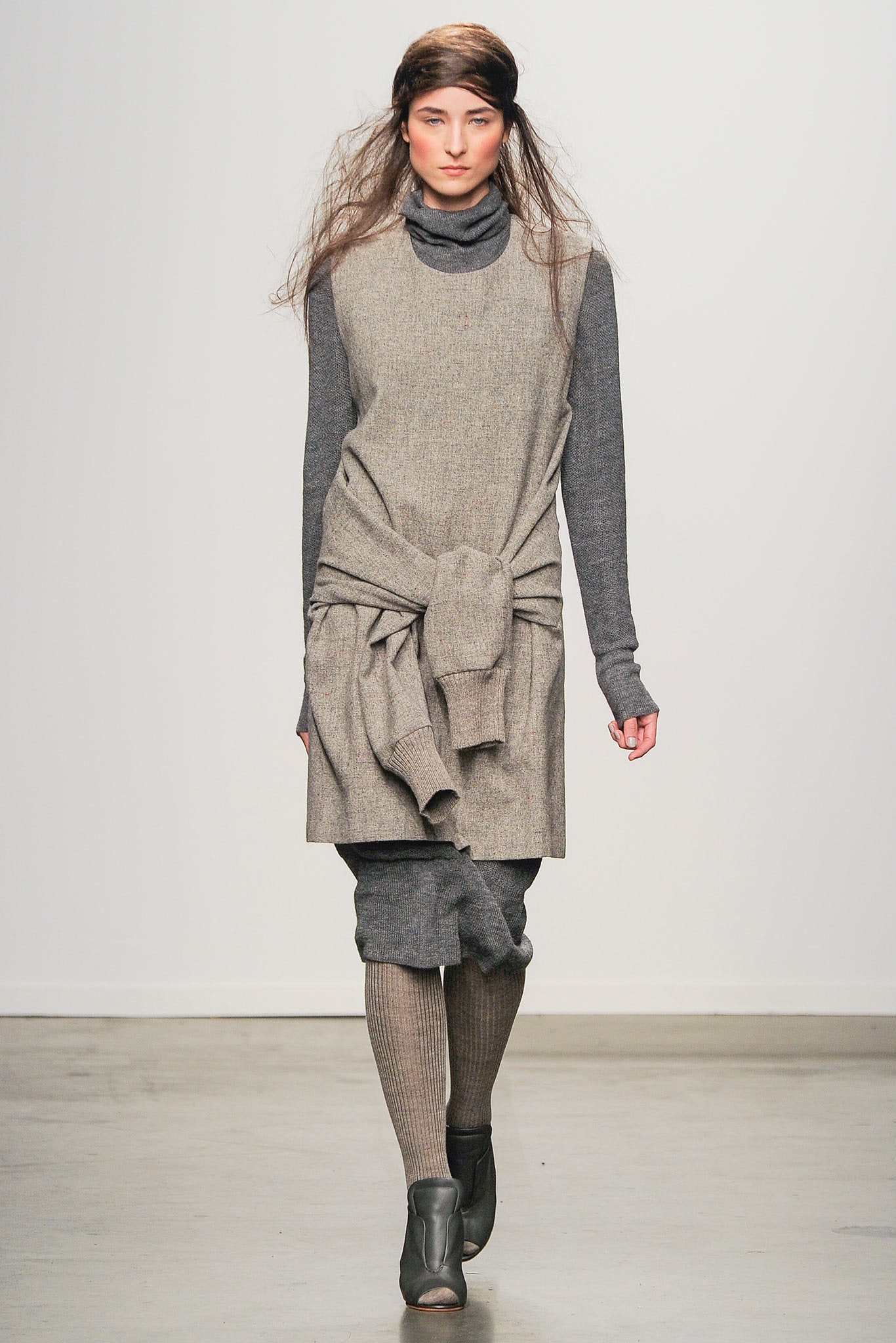 A relaxed gray wool dress with long sleeves and a turtleneck, featuring a layered design.