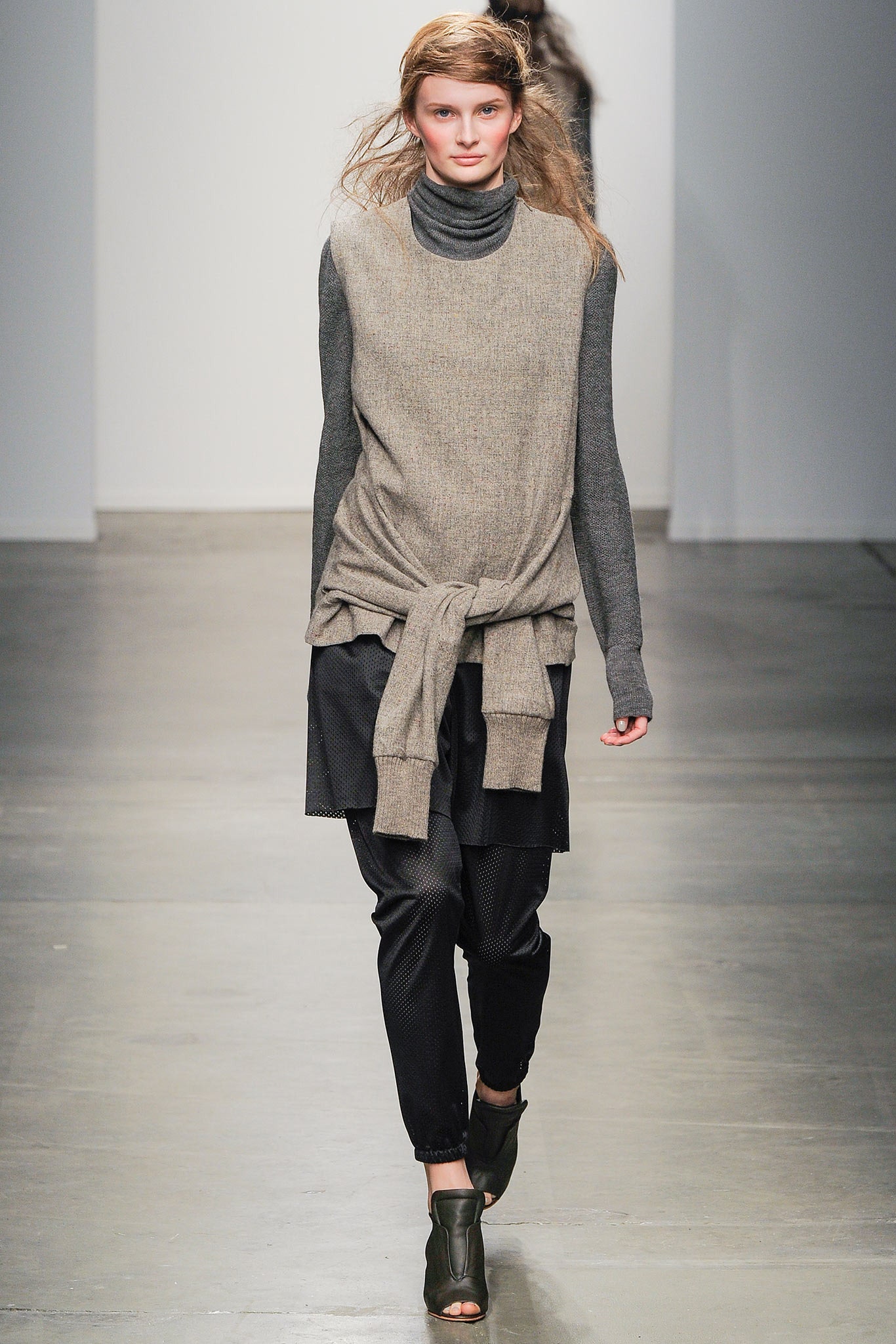A relaxed gray wool long-sleeve top with a turtleneck, paired with black pants.
