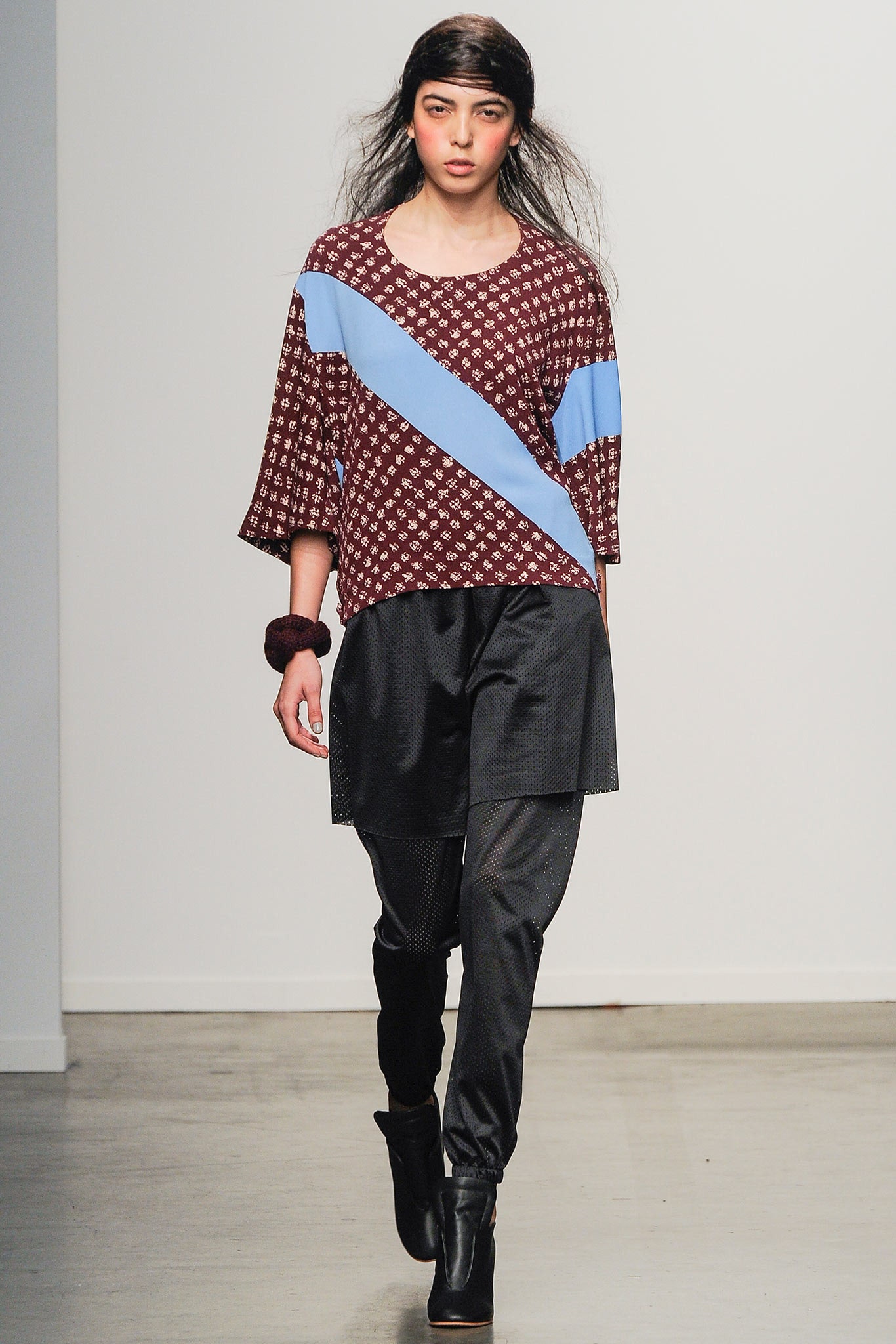 A relaxed-fit burgundy printed top paired with black pants, featuring blue accents.