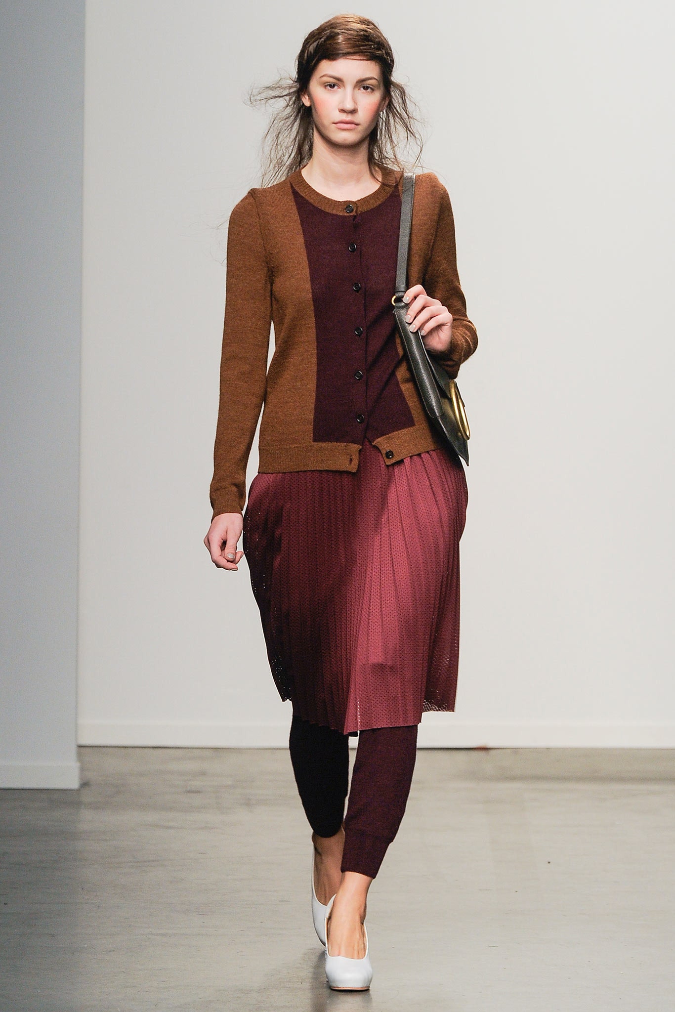 A fitted brown and burgundy dress layered with a long-sleeve cardigan featuring pleated details.