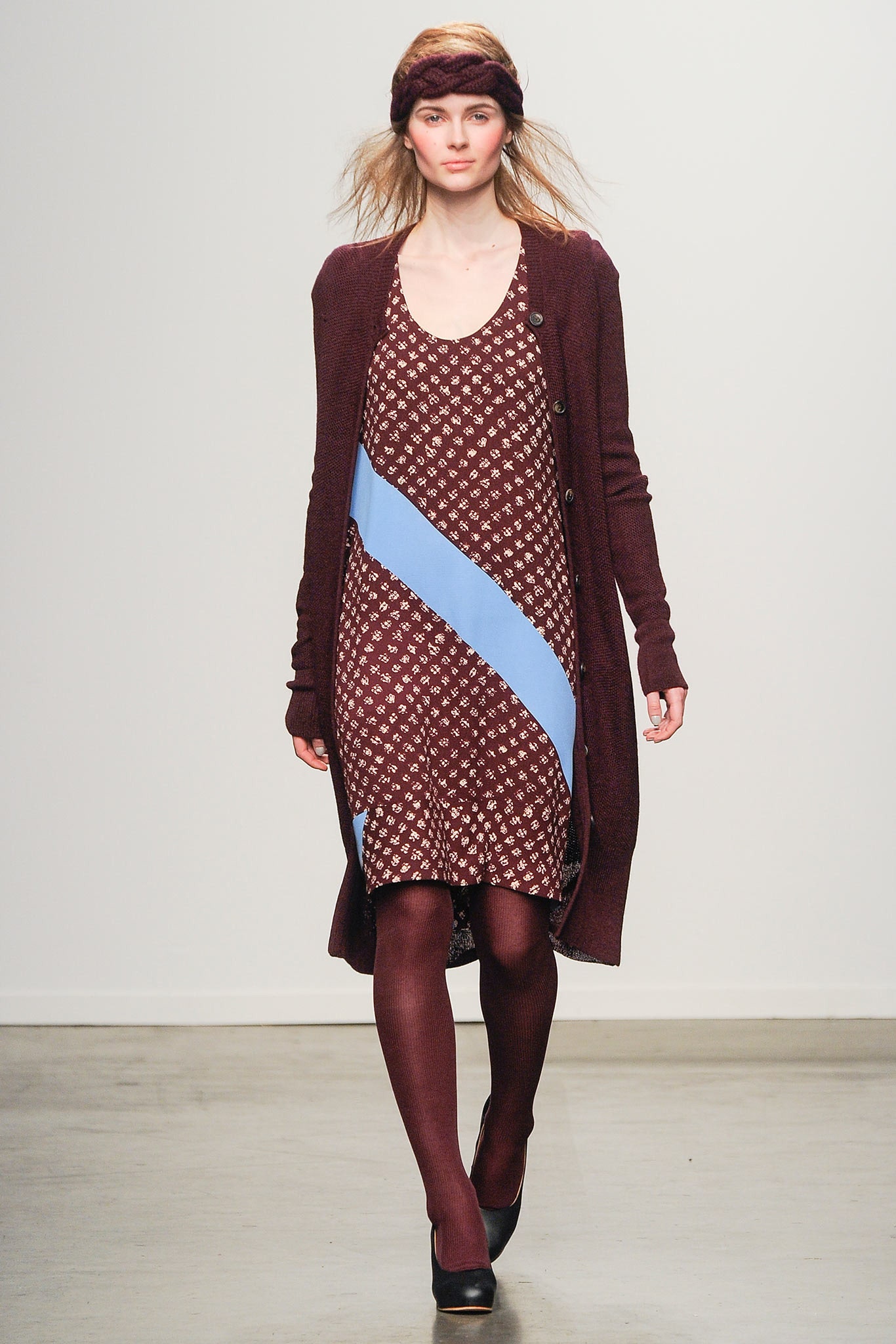 A relaxed brown printed sleeveless dress layered with a long cardigan featuring blue accents.