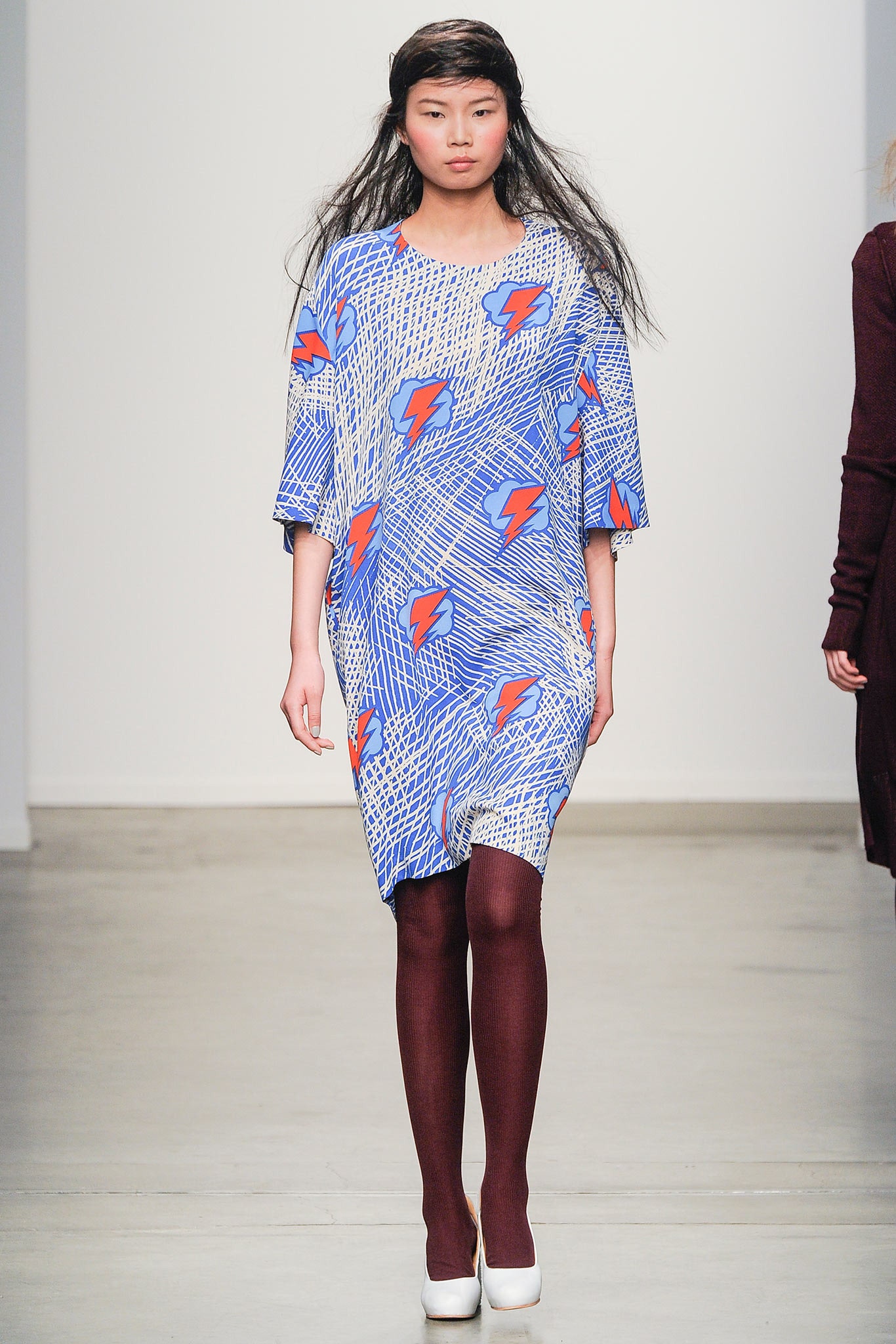 A relaxed blue dress with long sleeves, a collared neckline, and a vibrant printed design.
