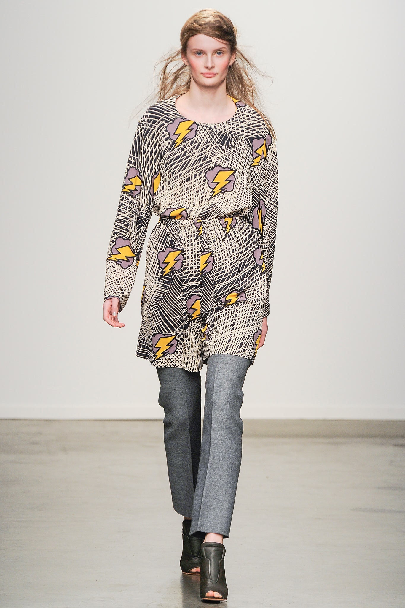 A relaxed multicolor printed top paired with gray pants, featuring long sleeves and a collared design.