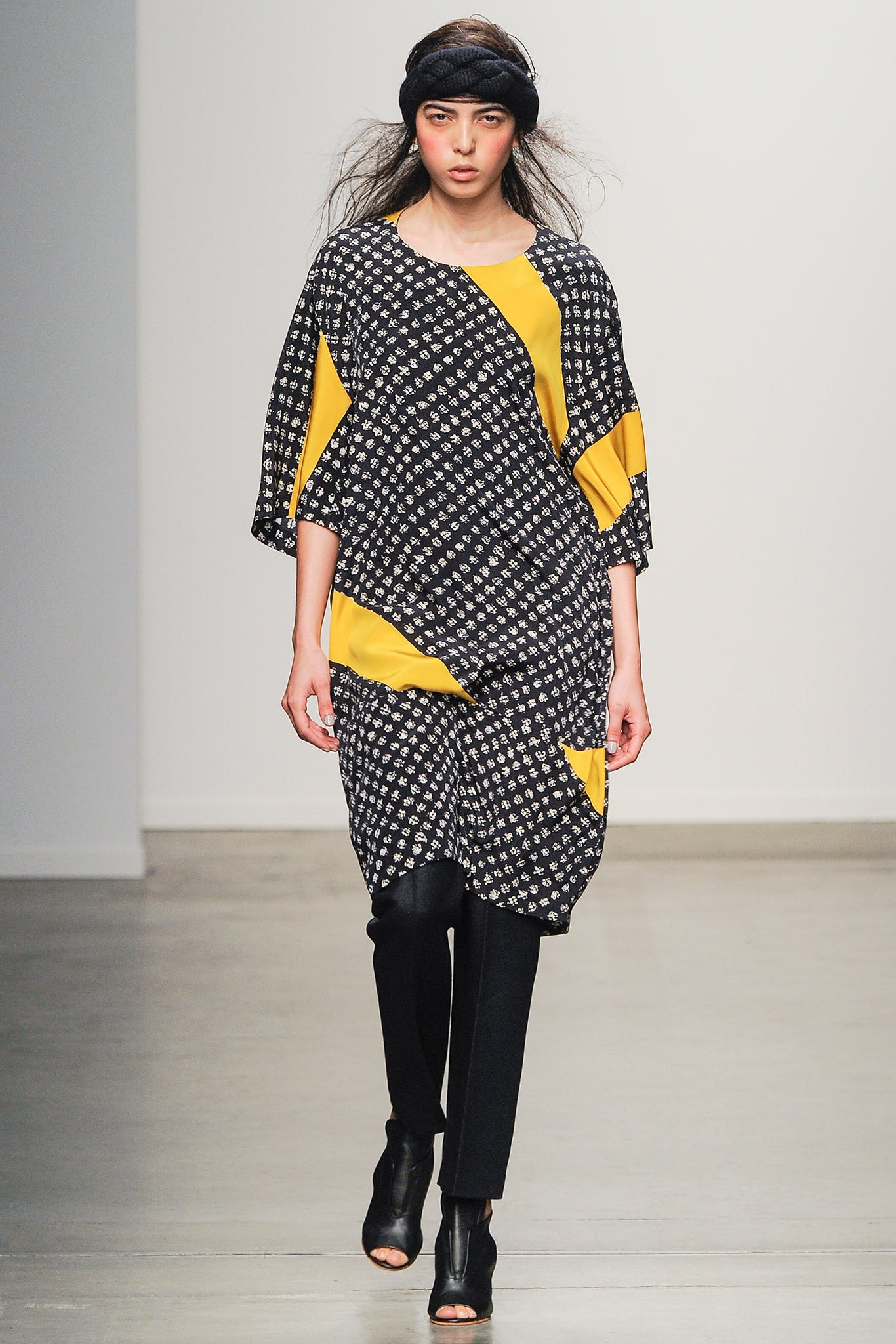 A relaxed black and yellow printed dress with short sleeves and an asymmetric design.