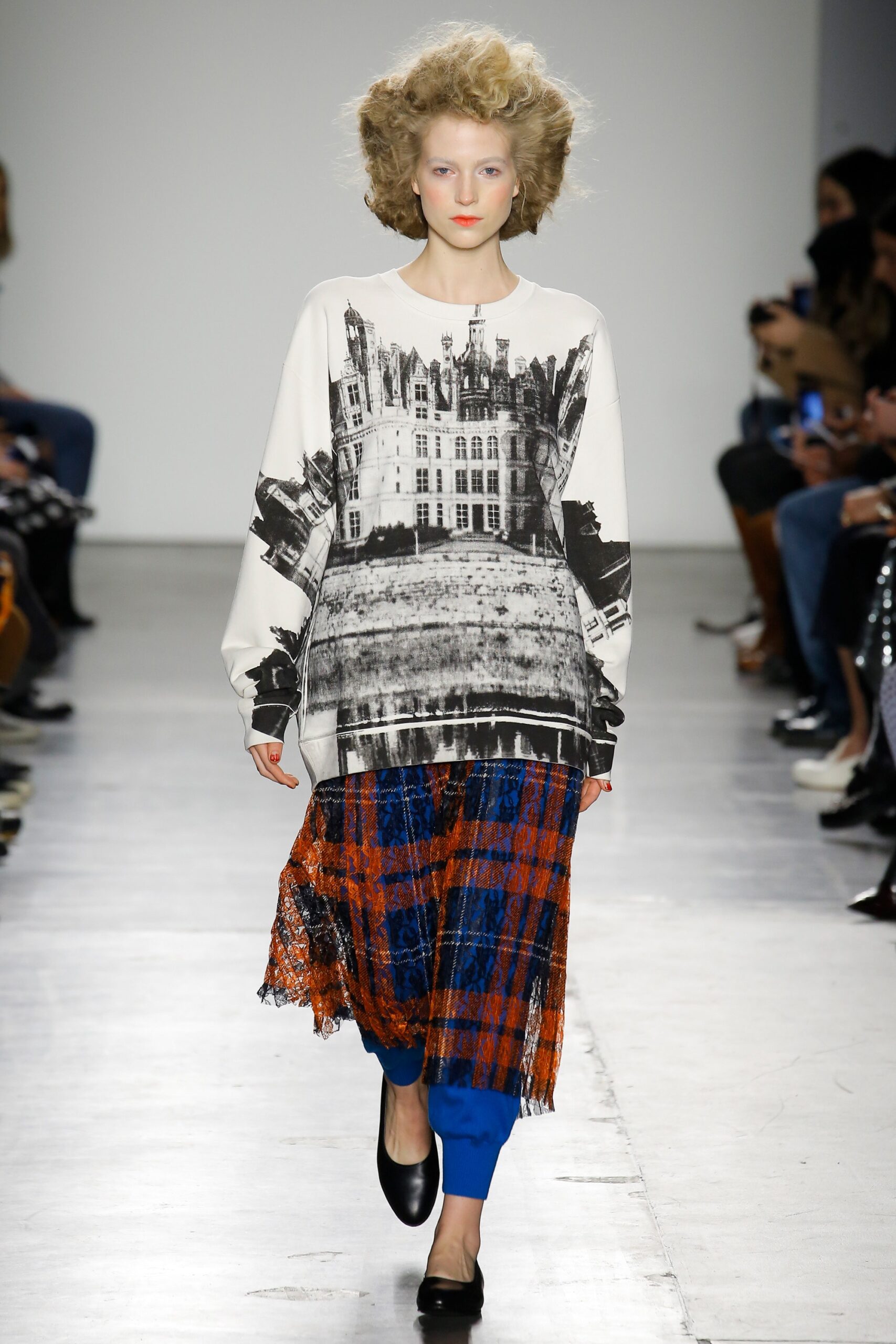 A relaxed long-sleeve top with a printed design paired with a layered skirt in vibrant colors.