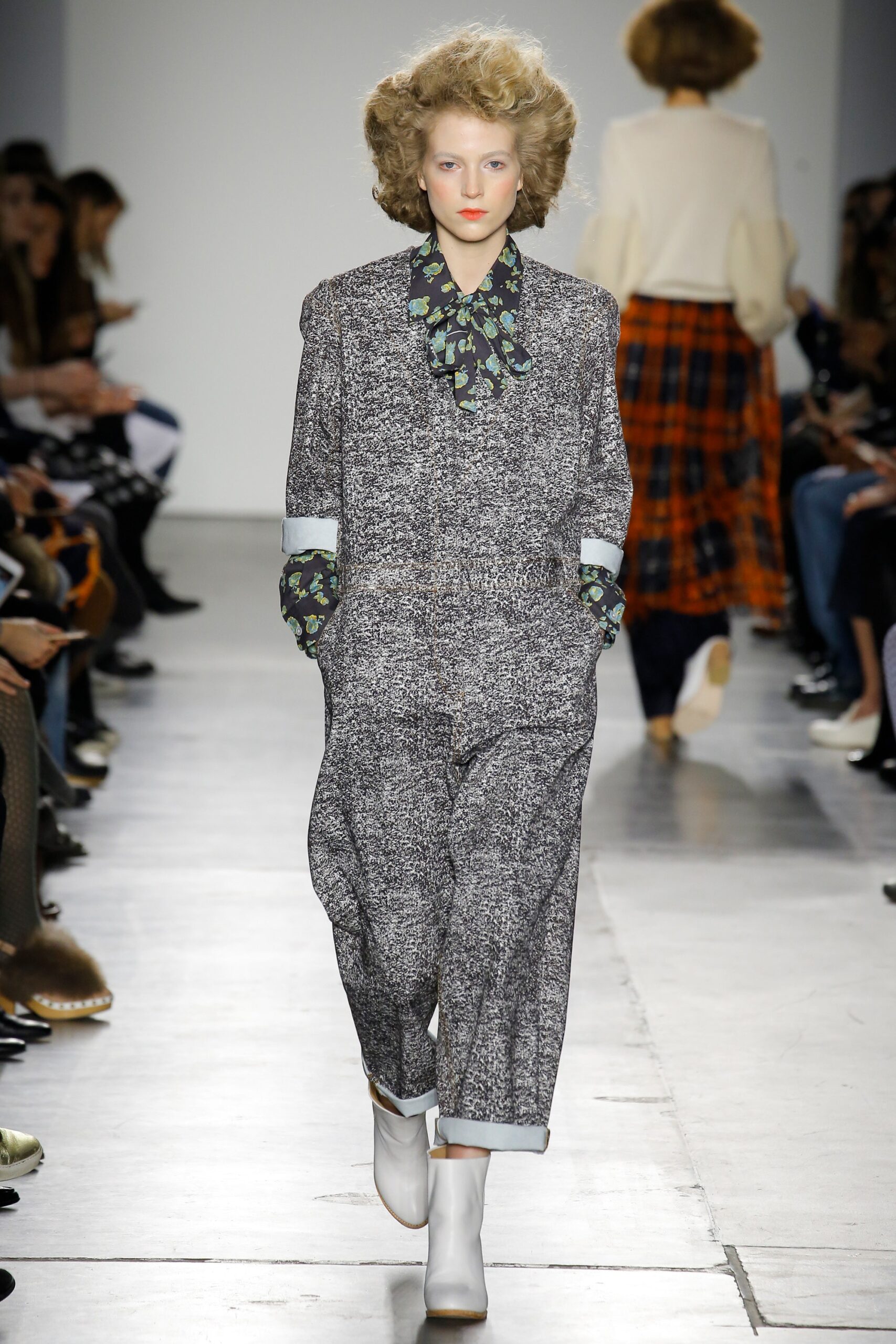 A relaxed gray printed jumpsuit with long sleeves and a collared neckline.