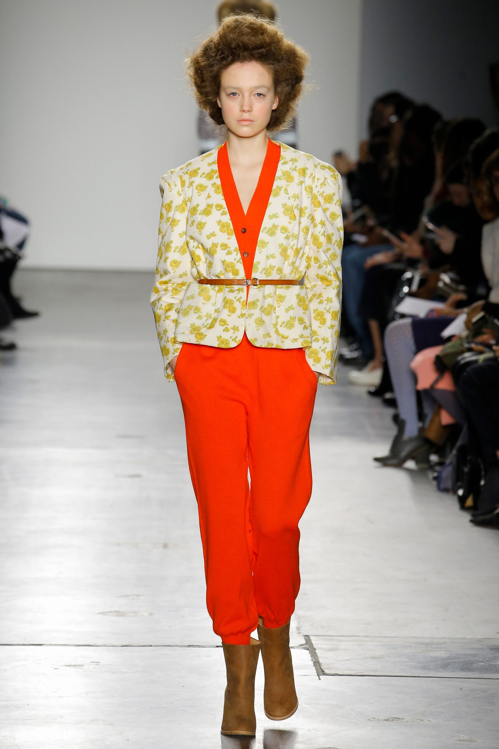 A fitted floral jacket with long sleeves paired with vibrant red pants.