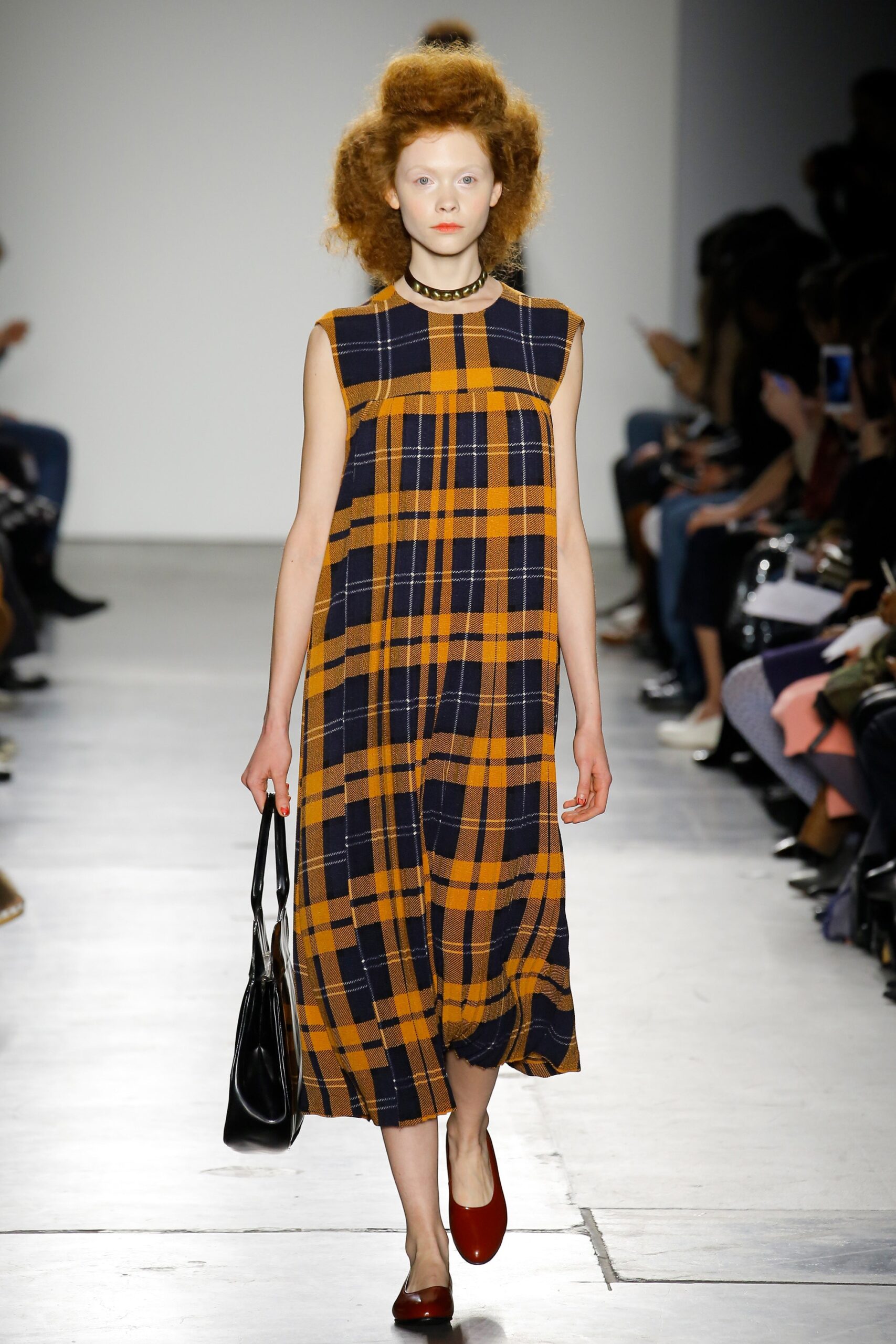 A relaxed sleeveless dress in orange and navy with a high neckline and checked pattern.