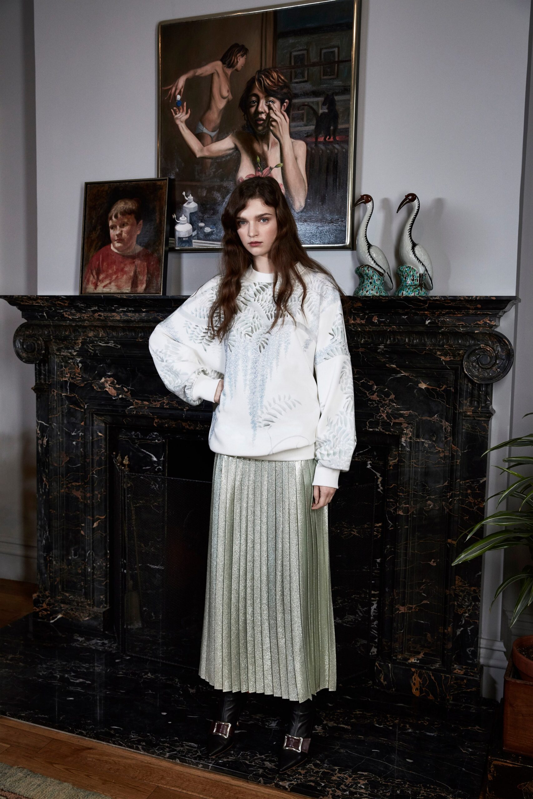 white embroidered sweater and green pleated skirt