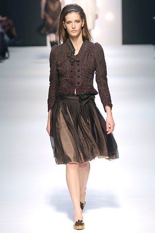 black embroidered jacket and brown pleated skirt