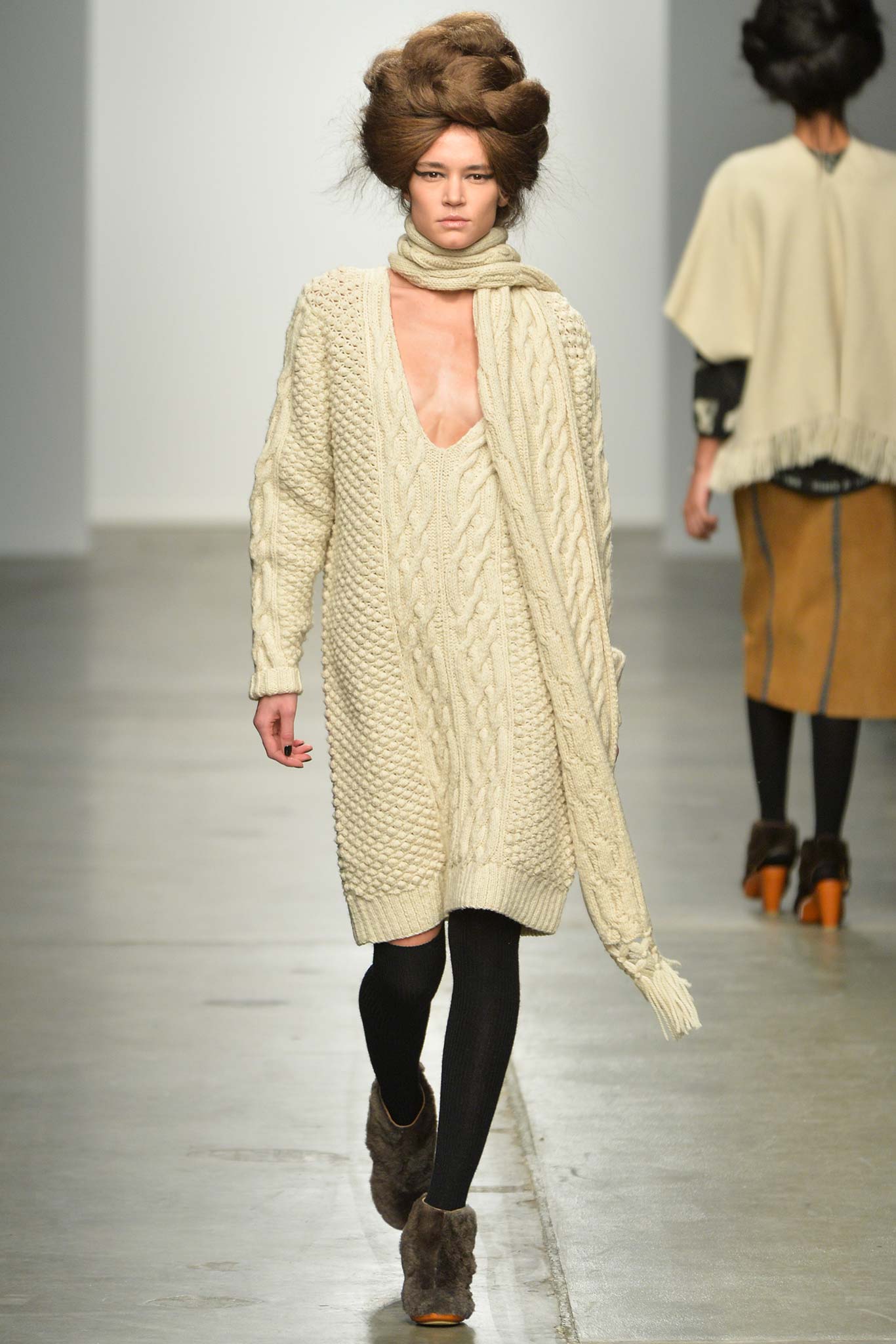 A relaxed cream knitted sleeveless dress with a V-neckline.
