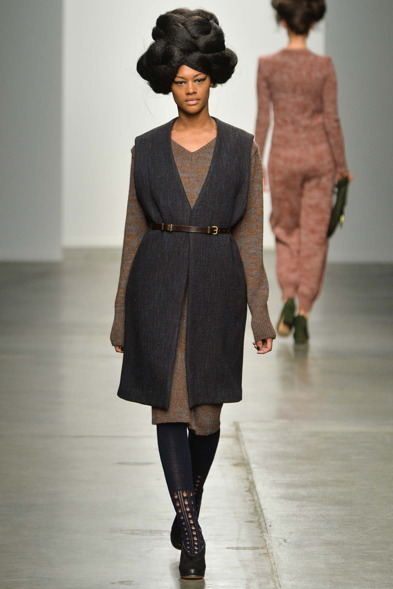 A fitted black wool dress layered with a sleeveless vest and V-neckline.