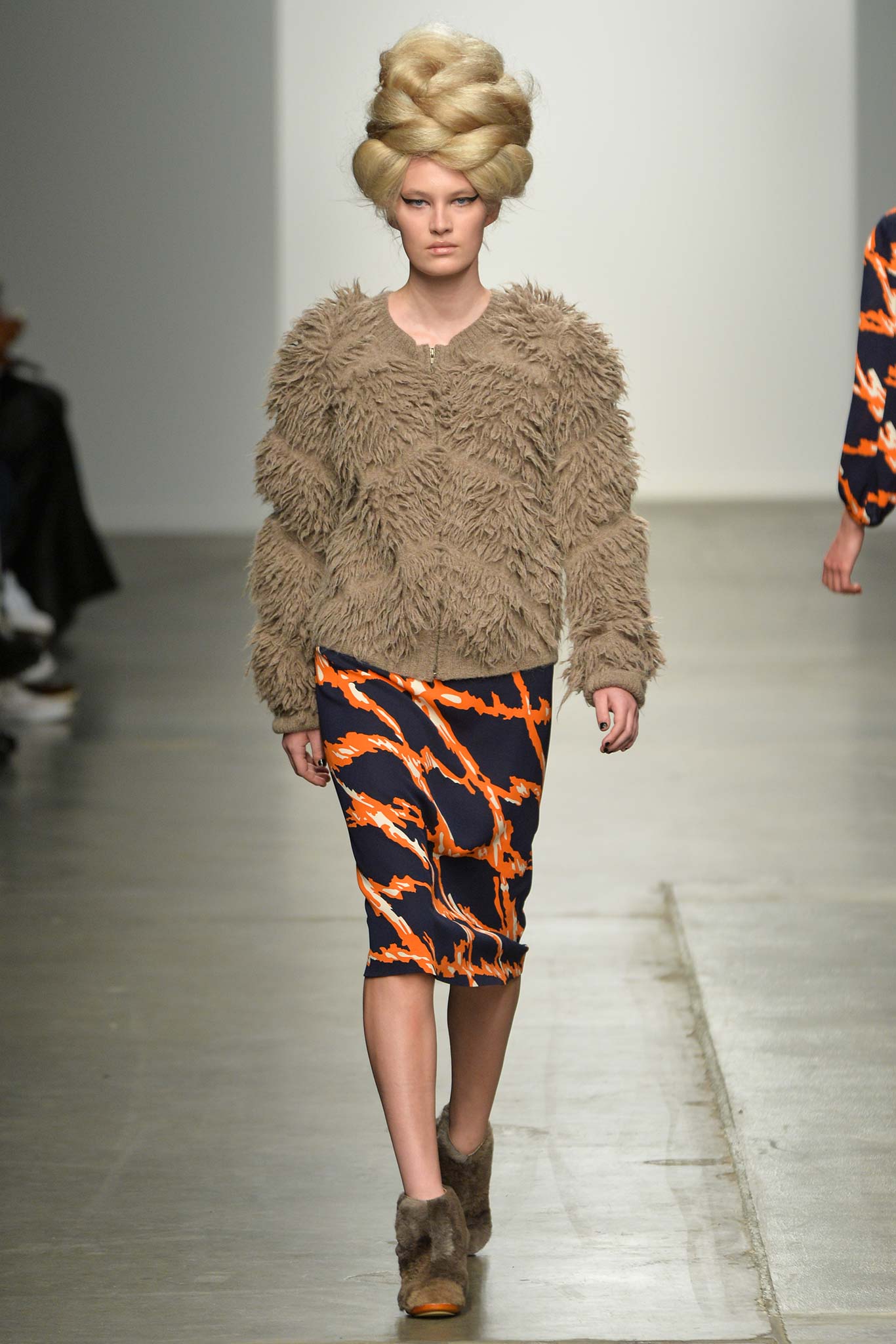 A fitted beige fur top with long sleeves paired with a printed pencil skirt in vibrant colors.