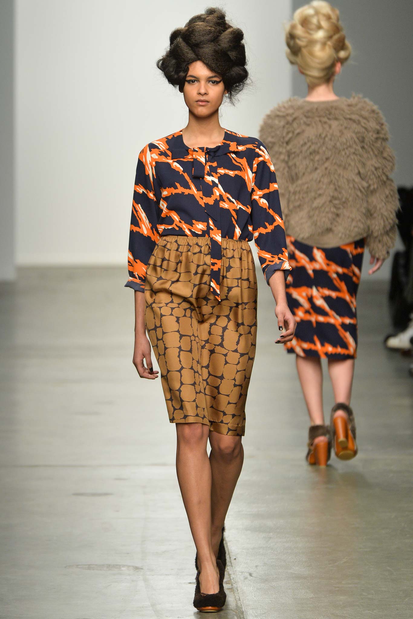 A fitted long-sleeve collared shirt paired with a printed pencil skirt in vibrant colors.