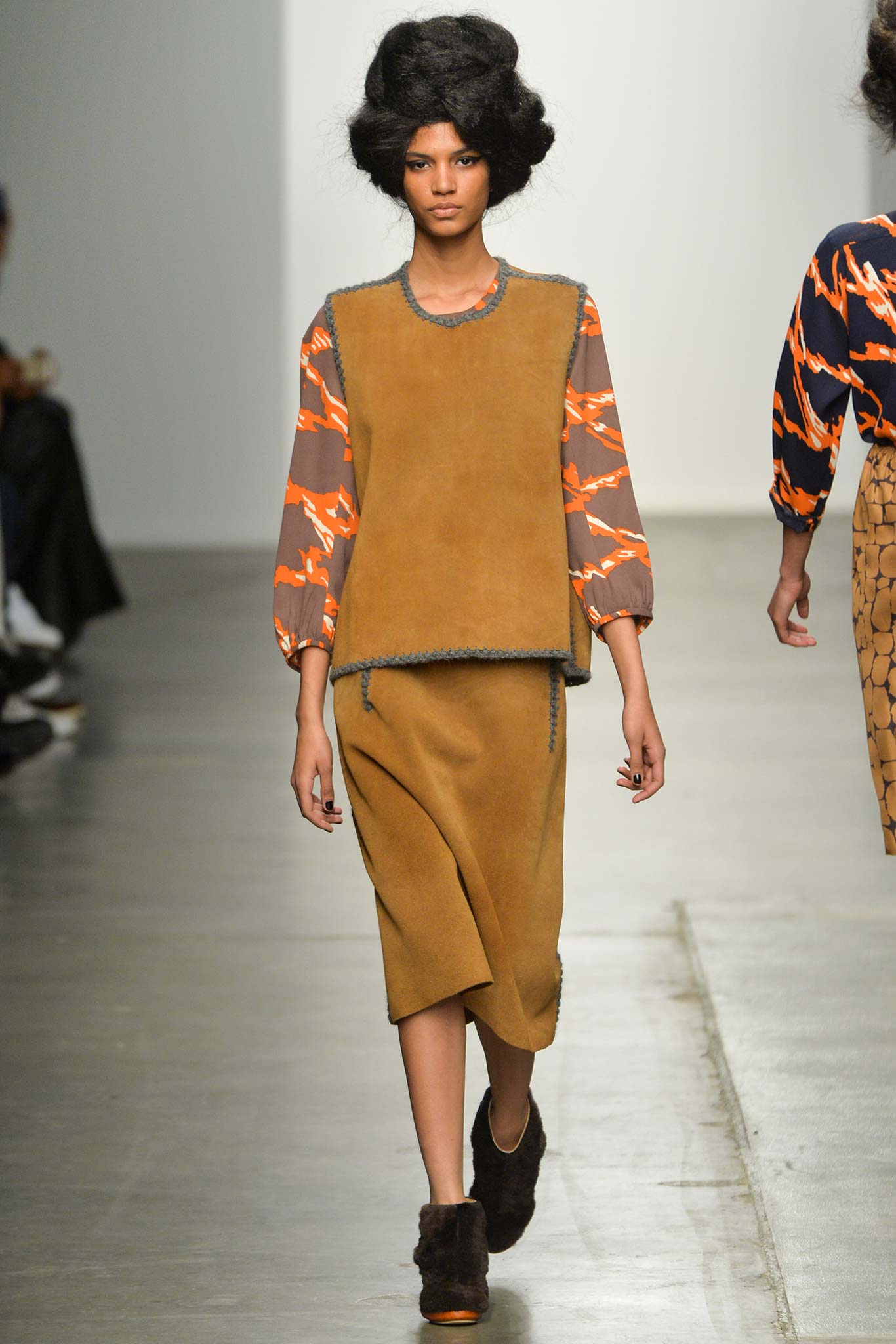 A relaxed brown wool top with long sleeves and an asymmetric skirt featuring orange accents.