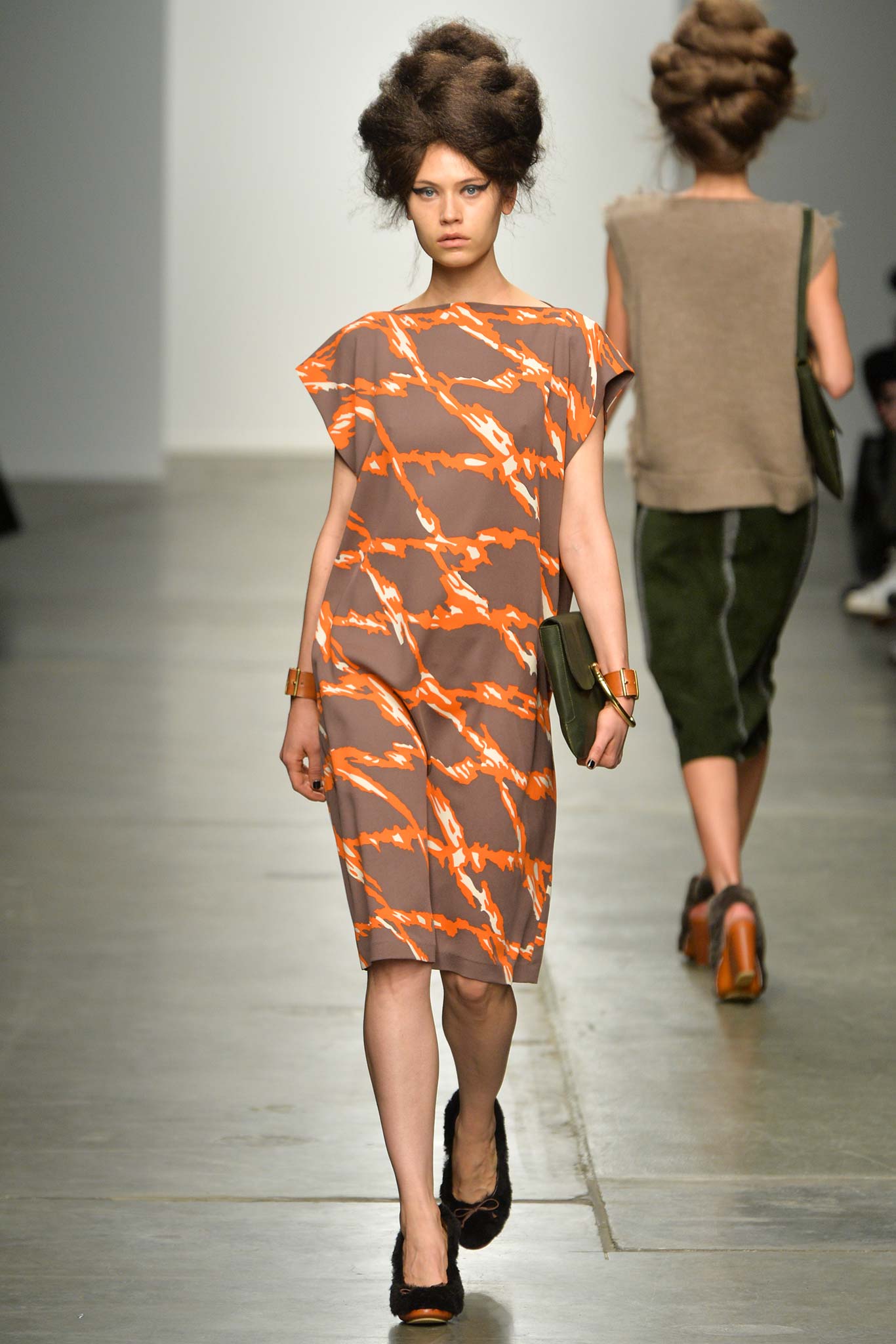 A relaxed brown and orange printed dress with short sleeves and a collared design.