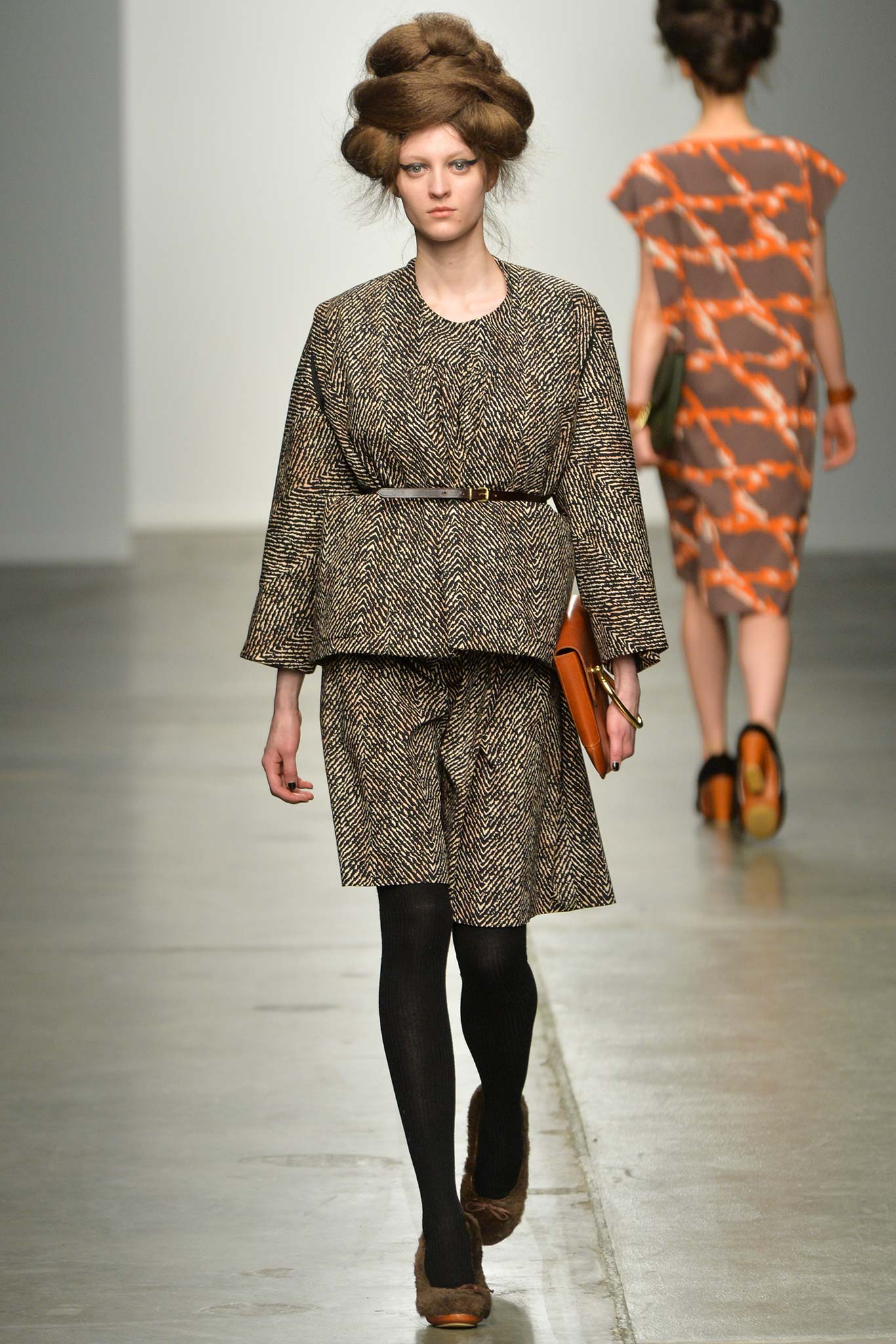 A relaxed brown cotton dress with long sleeves, a collared neckline, and pleated details.