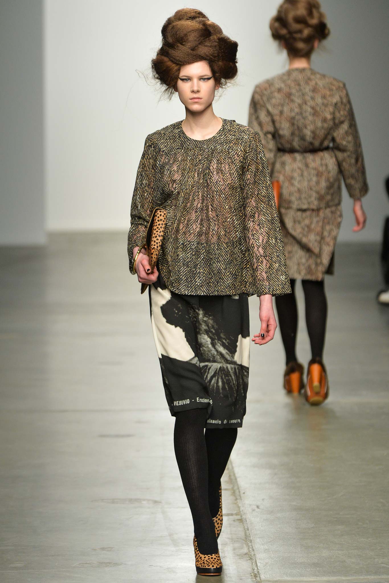 A relaxed brown printed top with long sleeves paired with a black skirt.