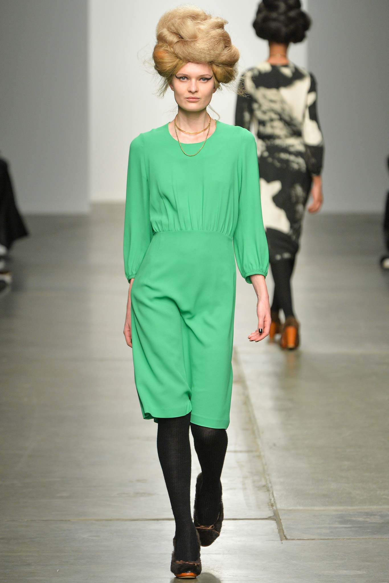 A fitted green dress with long sleeves and a collared neckline.