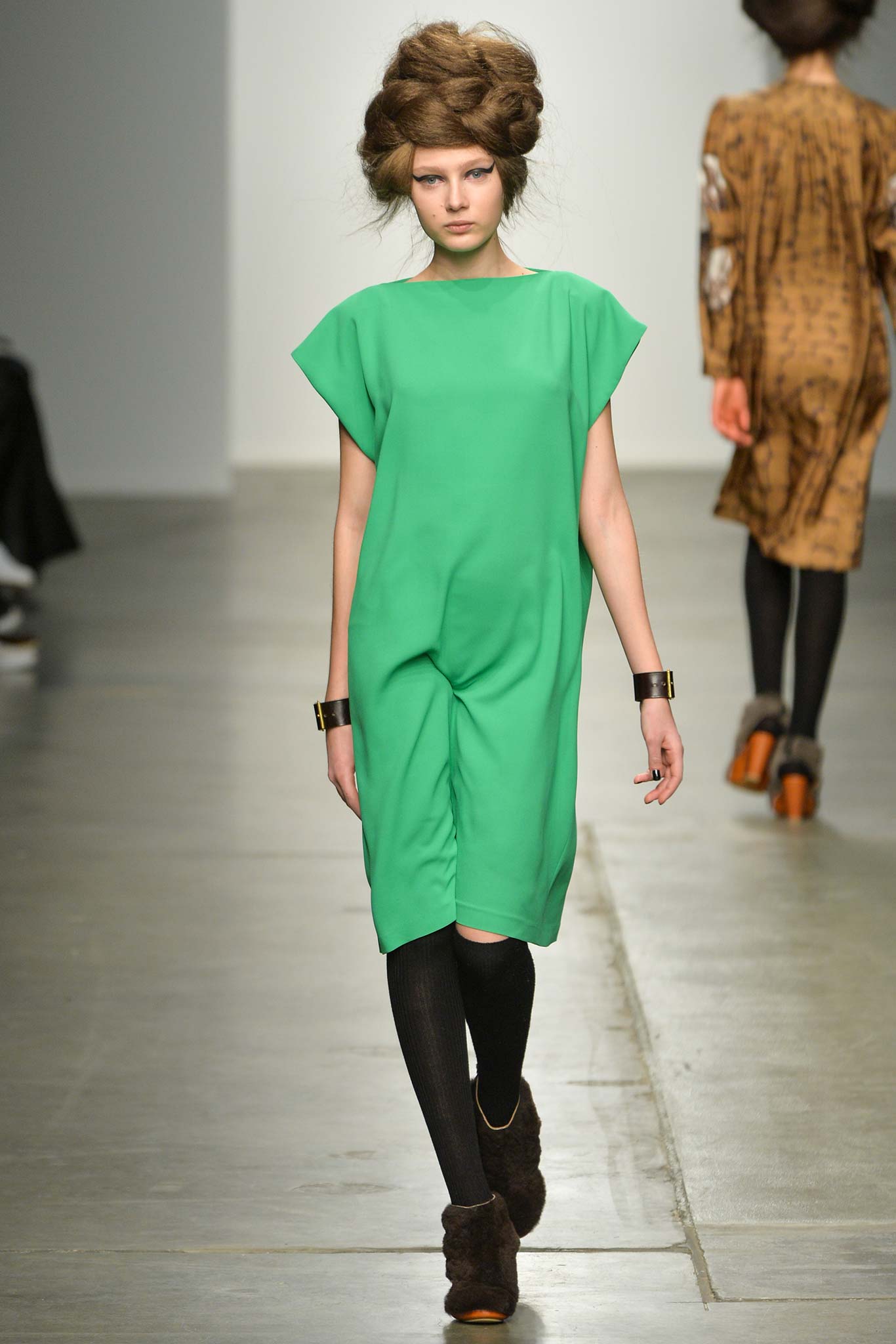A relaxed green sleeveless dress with a high neckline and straight silhouette.