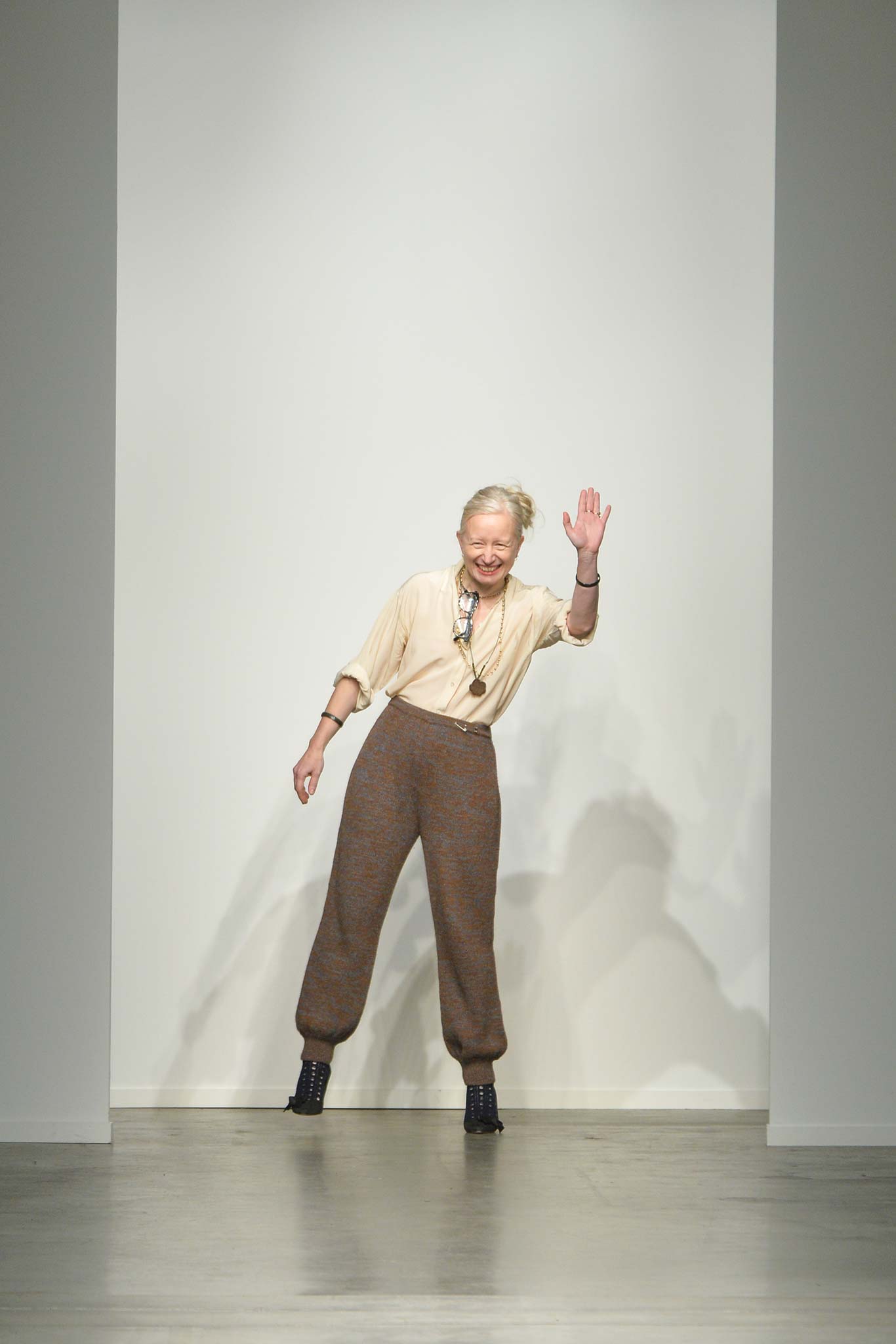 A relaxed beige cotton blouse paired with brown wool straight-leg pants.