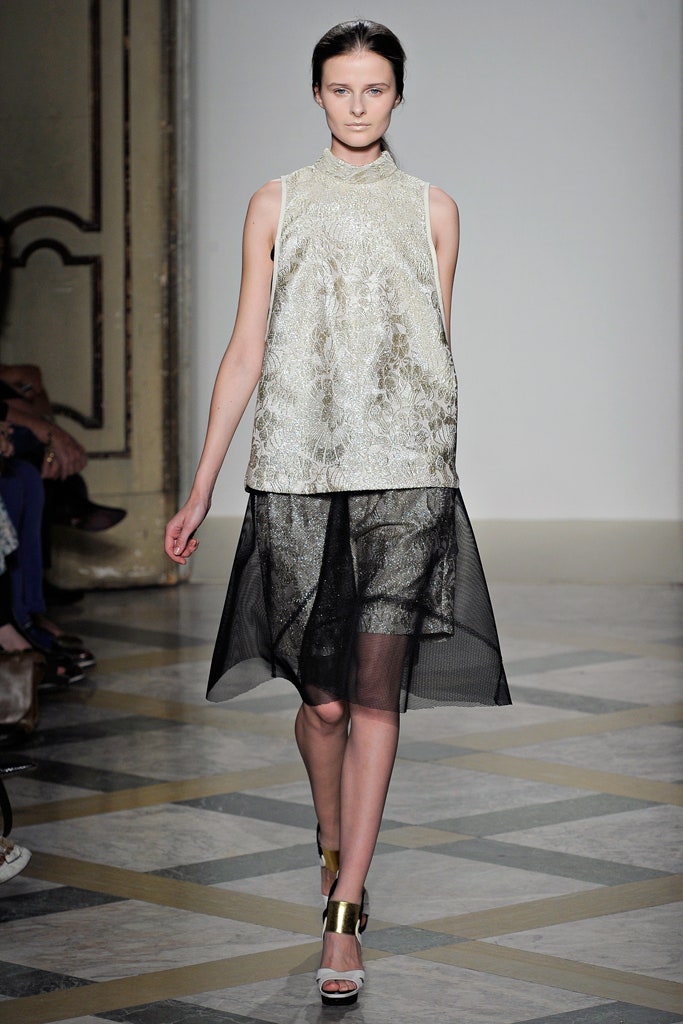 gold embroidered sleeveless top with black skirt