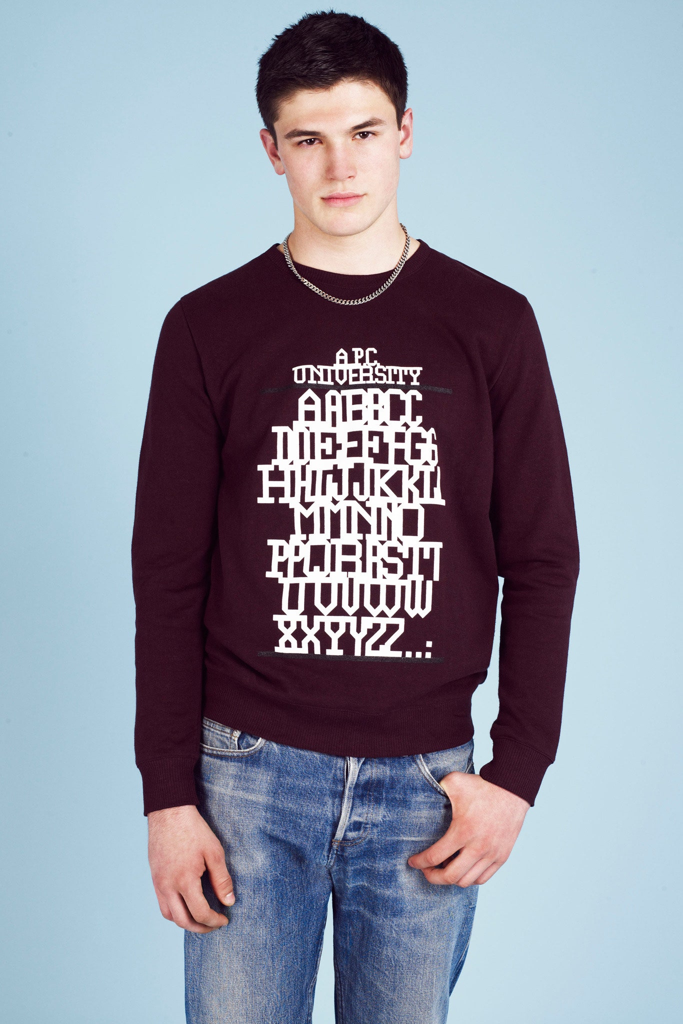 burgundy printed sweater with blue jeans