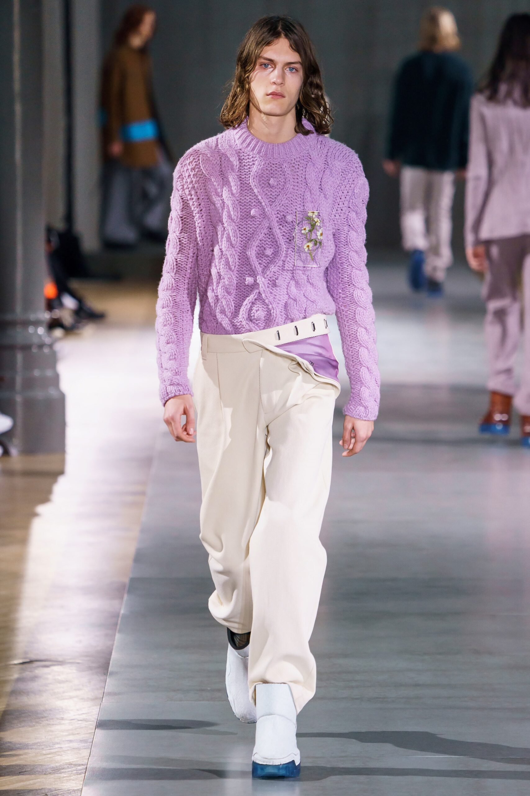 purple fitted sweater and beige pants
