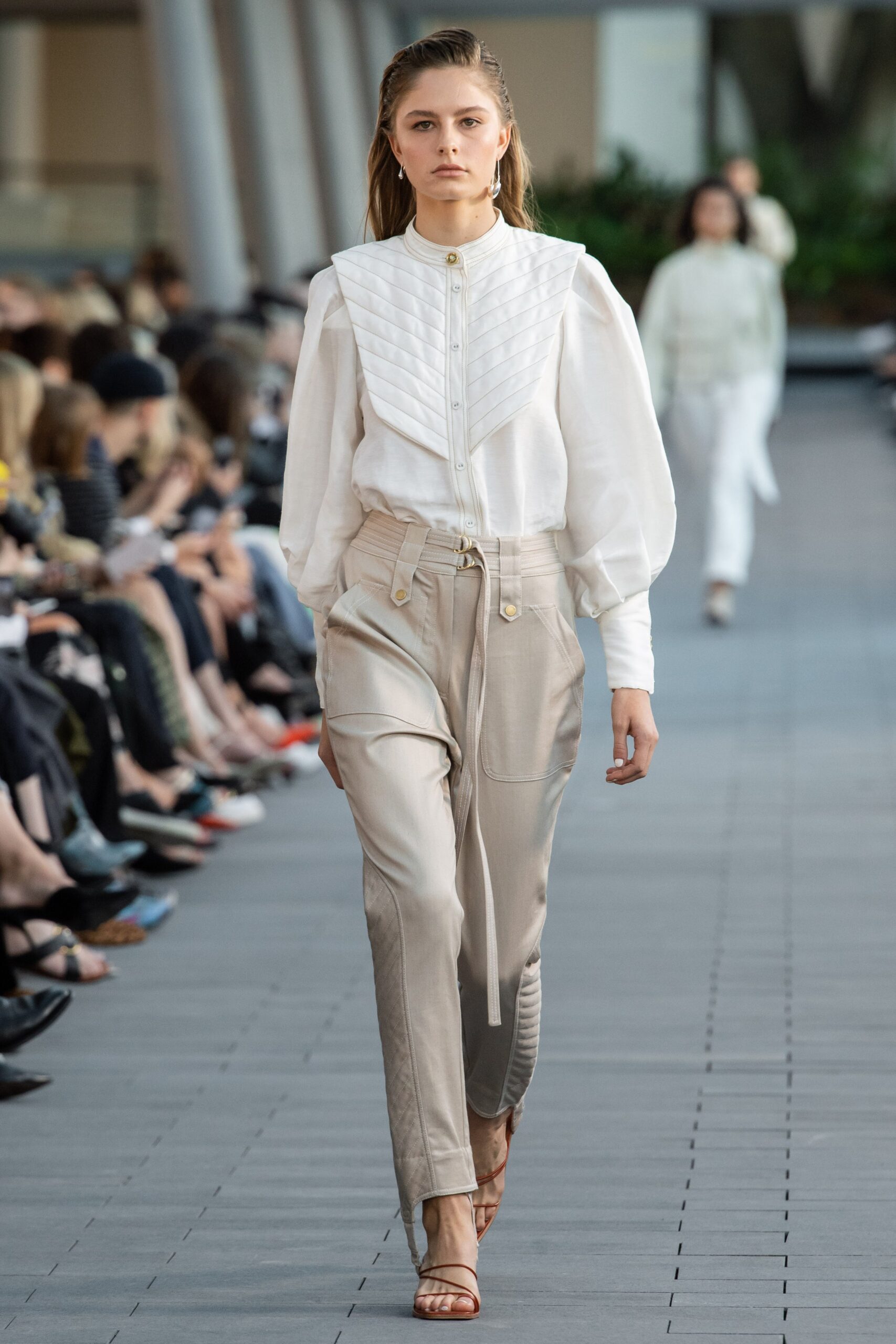 white pleated blouse with beige pants