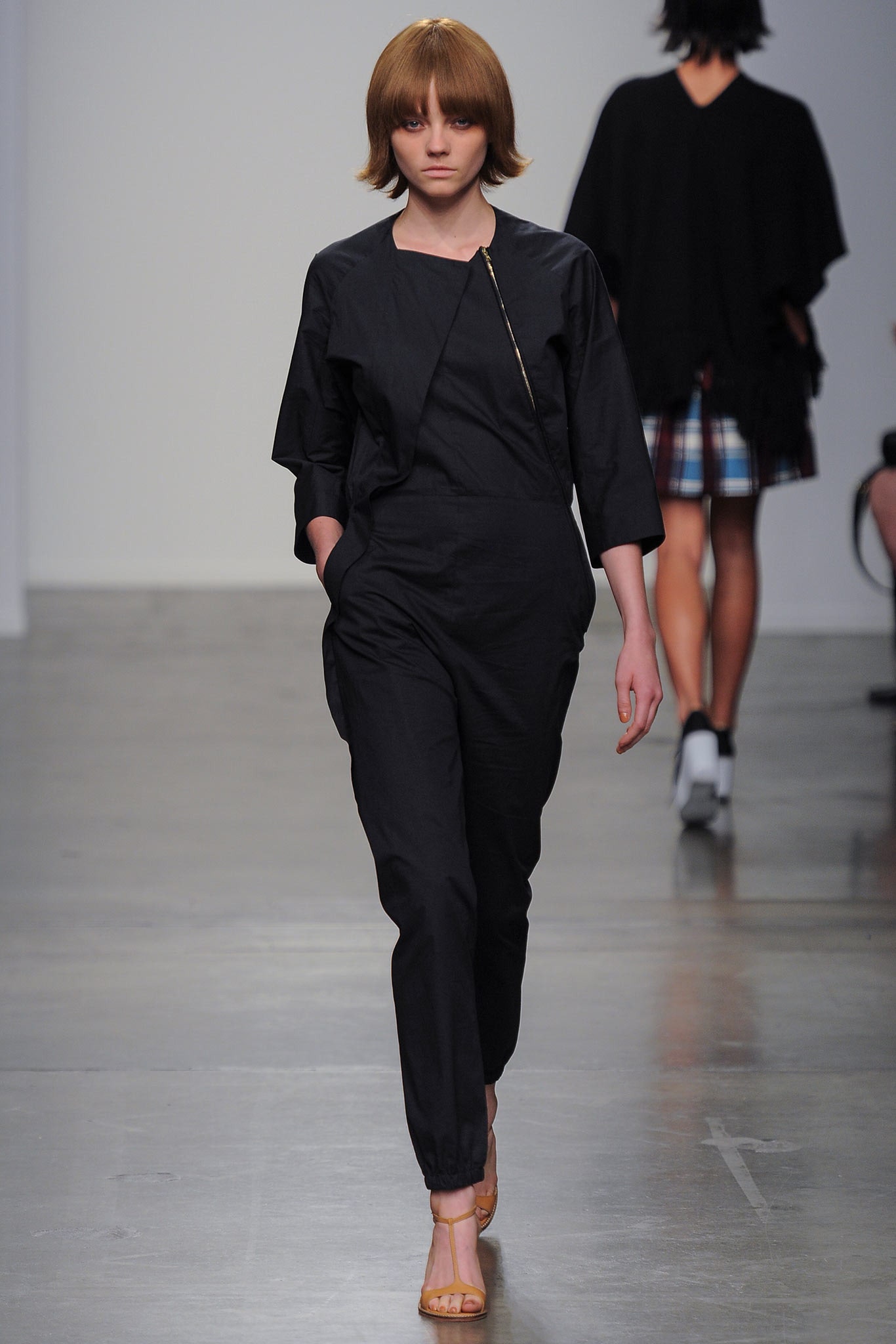 A relaxed black jumpsuit with long sleeves and a zippered detail for a modern look.