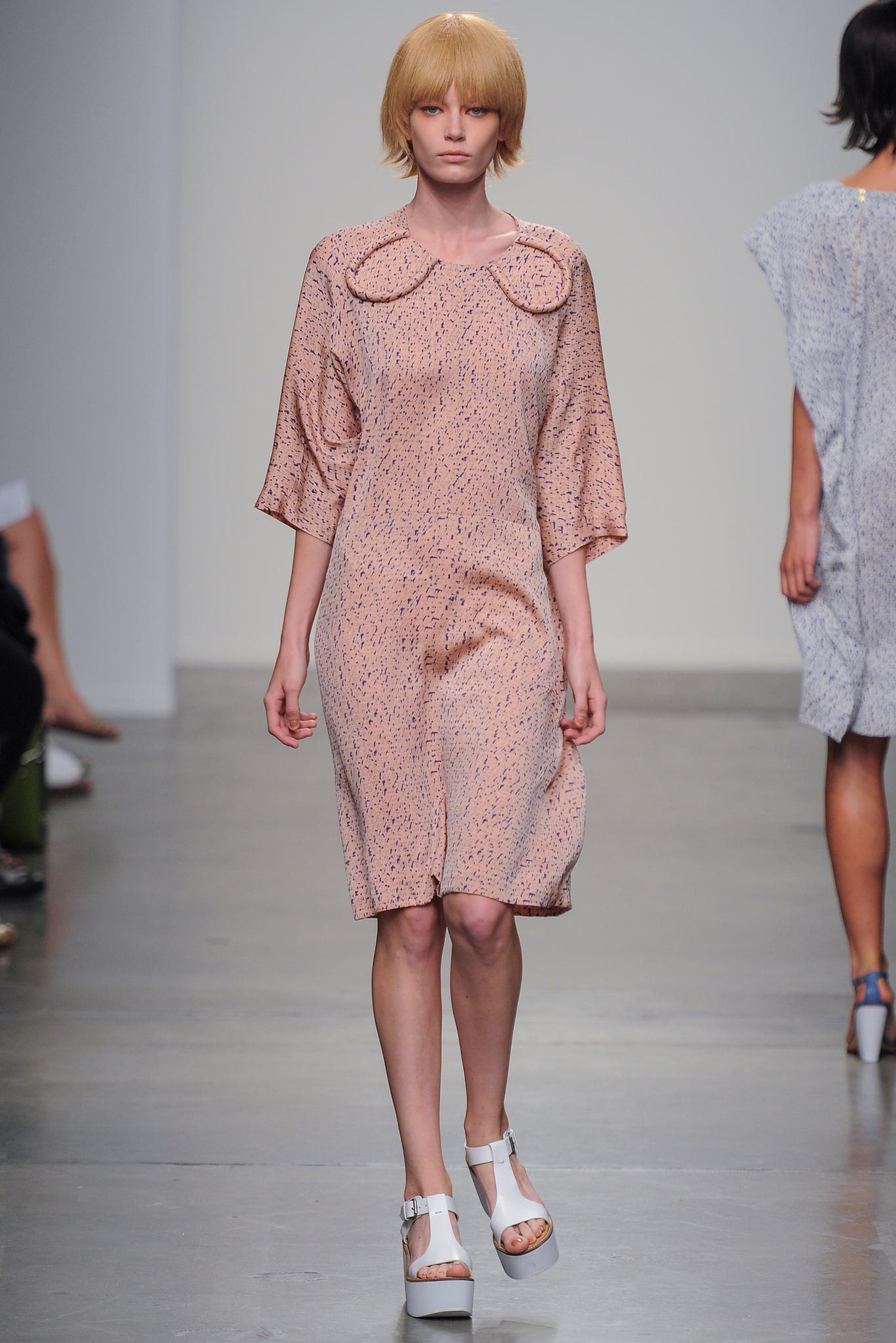 A relaxed pink dress with short sleeves and a collared neckline featuring a printed design.