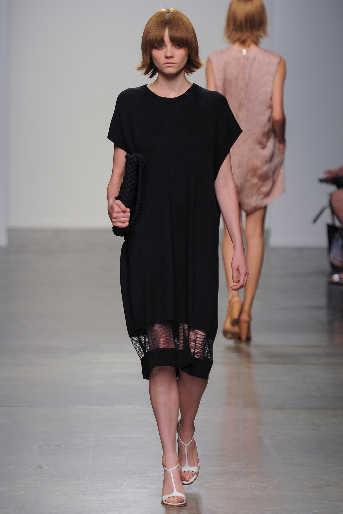 A relaxed black cotton dress with short sleeves and an asymmetric design.