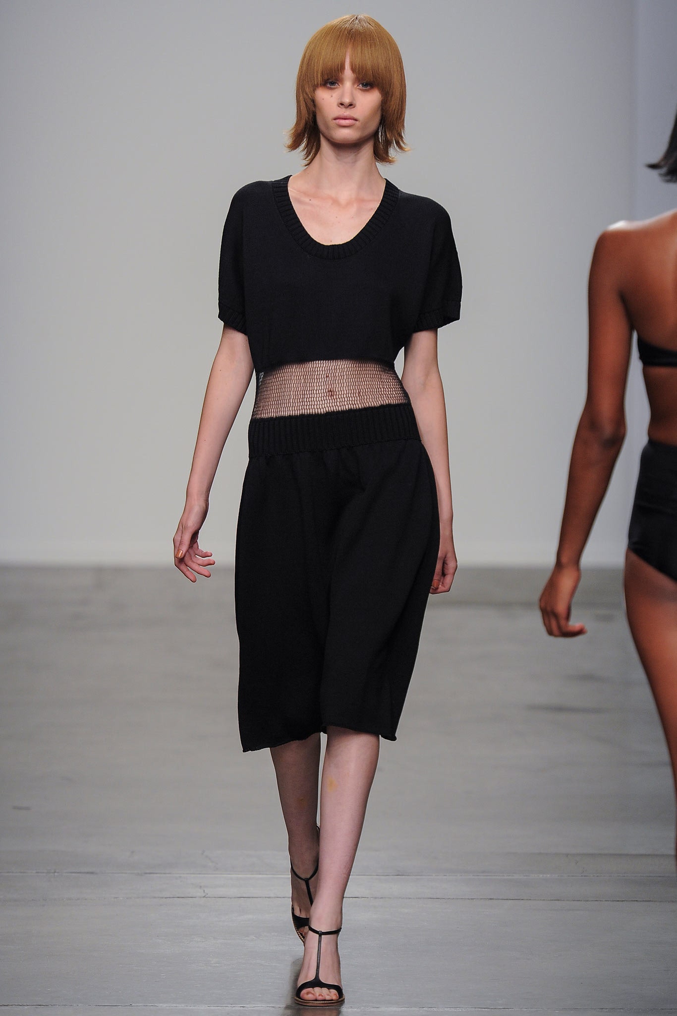 A relaxed black dress with short sleeves and a V-neckline featuring an asymmetric design.