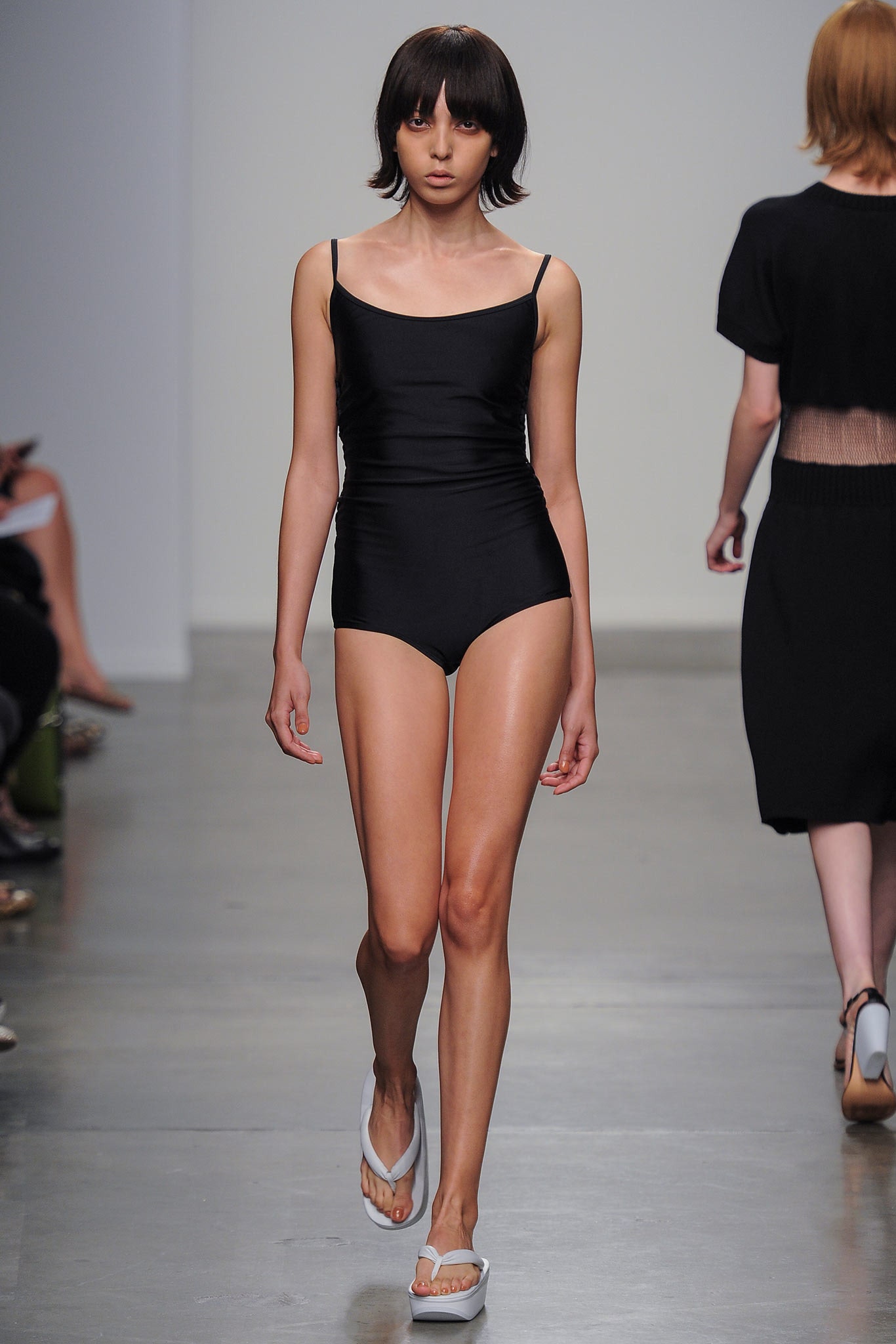 A fitted black swimsuit with a sleeveless design and high-neck construction.