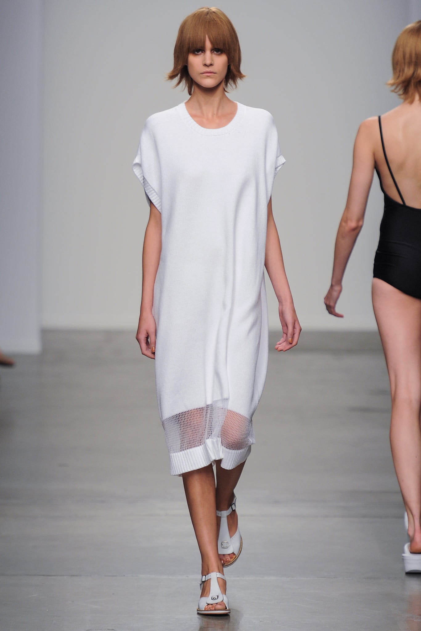 A relaxed white cotton dress with short sleeves and a layered design detail.