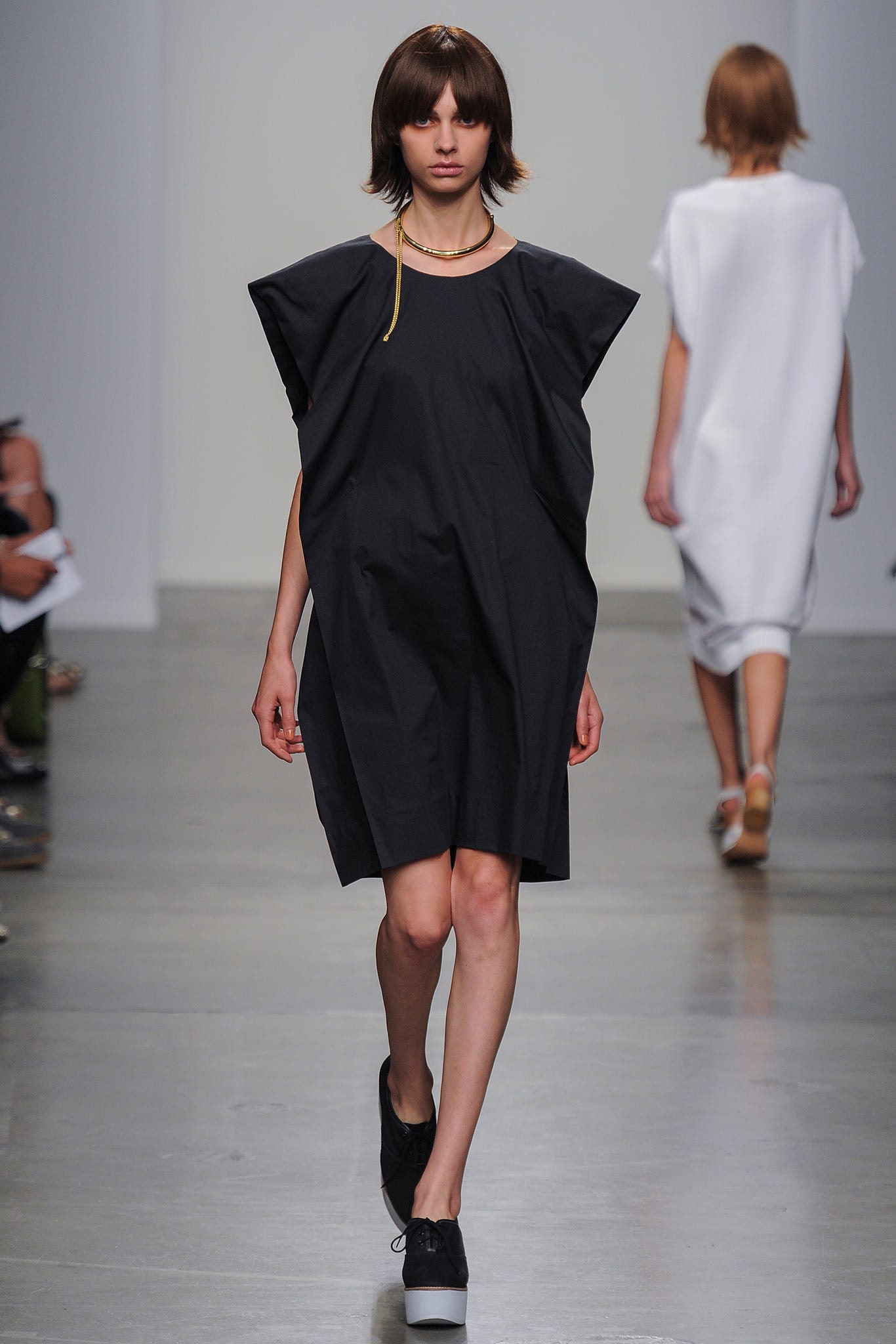 An oversized black cotton dress with a high neckline and asymmetric design.