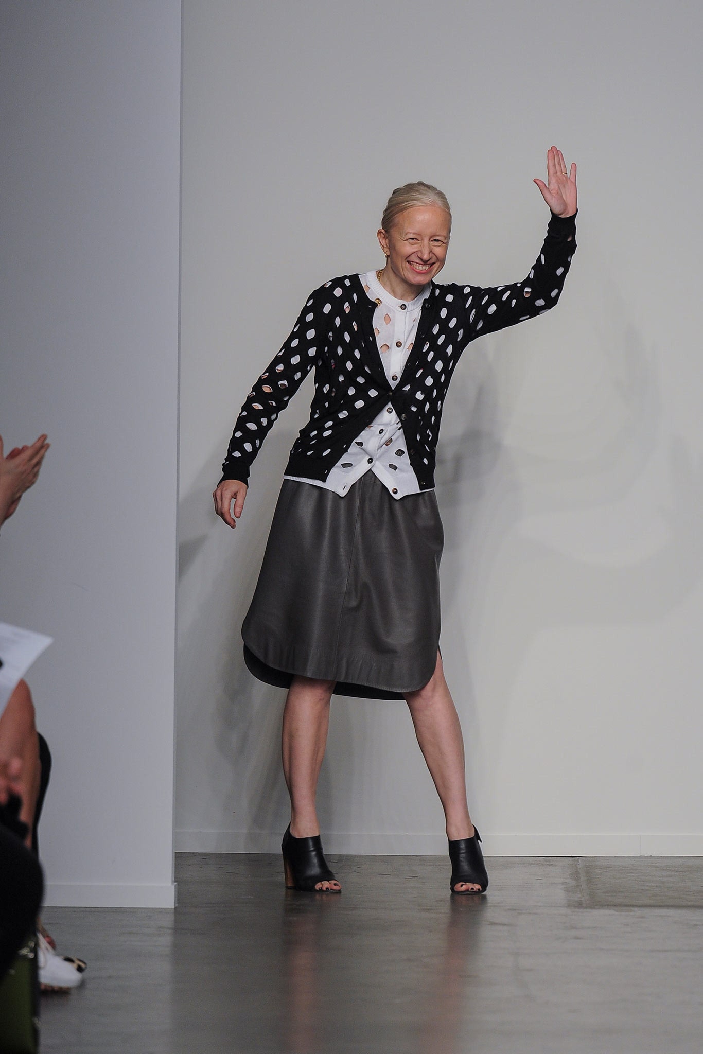 A fitted black leather skirt paired with a long-sleeve printed white blouse.