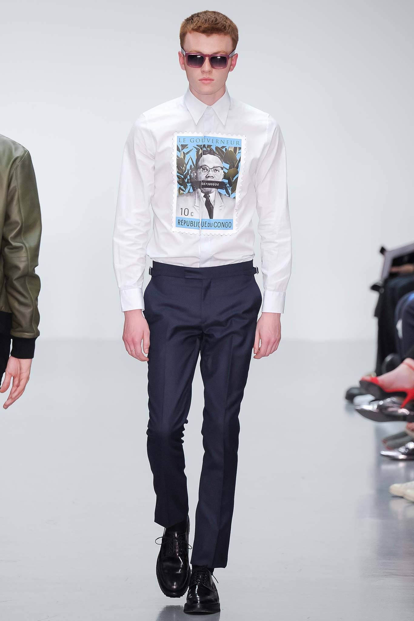 This fitted shirt features a striking print that adds a contemporary edge to a classic silhouette, complemented by tailored navy pants that enhance the overall sharpness of the look. The long sleeves and collared design provide a polished finish, making it a versatile choice for various occasions.
