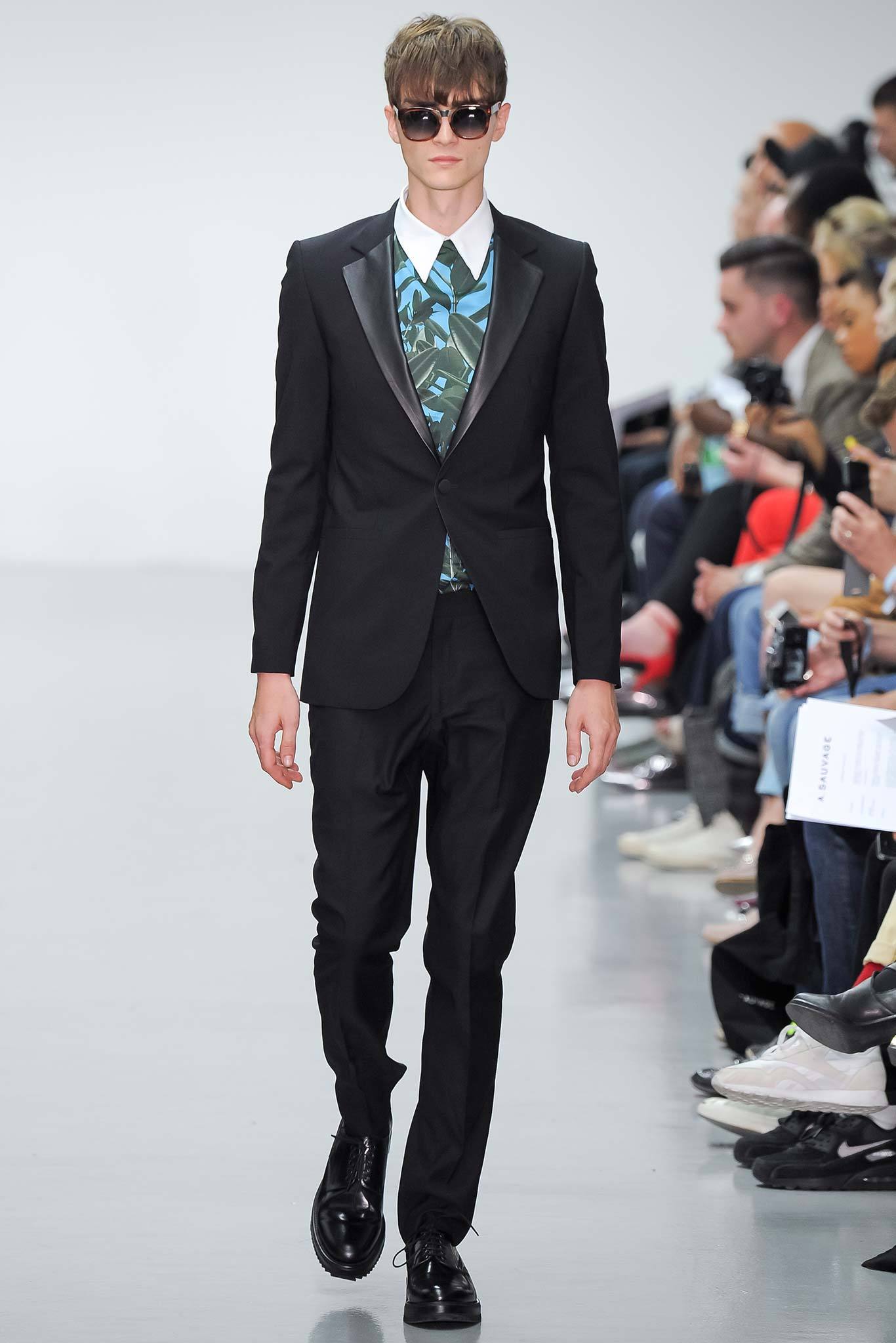 This tailored black suit features a structured silhouette that exudes sophistication. The long-sleeve collared shirt beneath adds a touch of contrast, while the buttoned details enhance its refined aesthetic.
