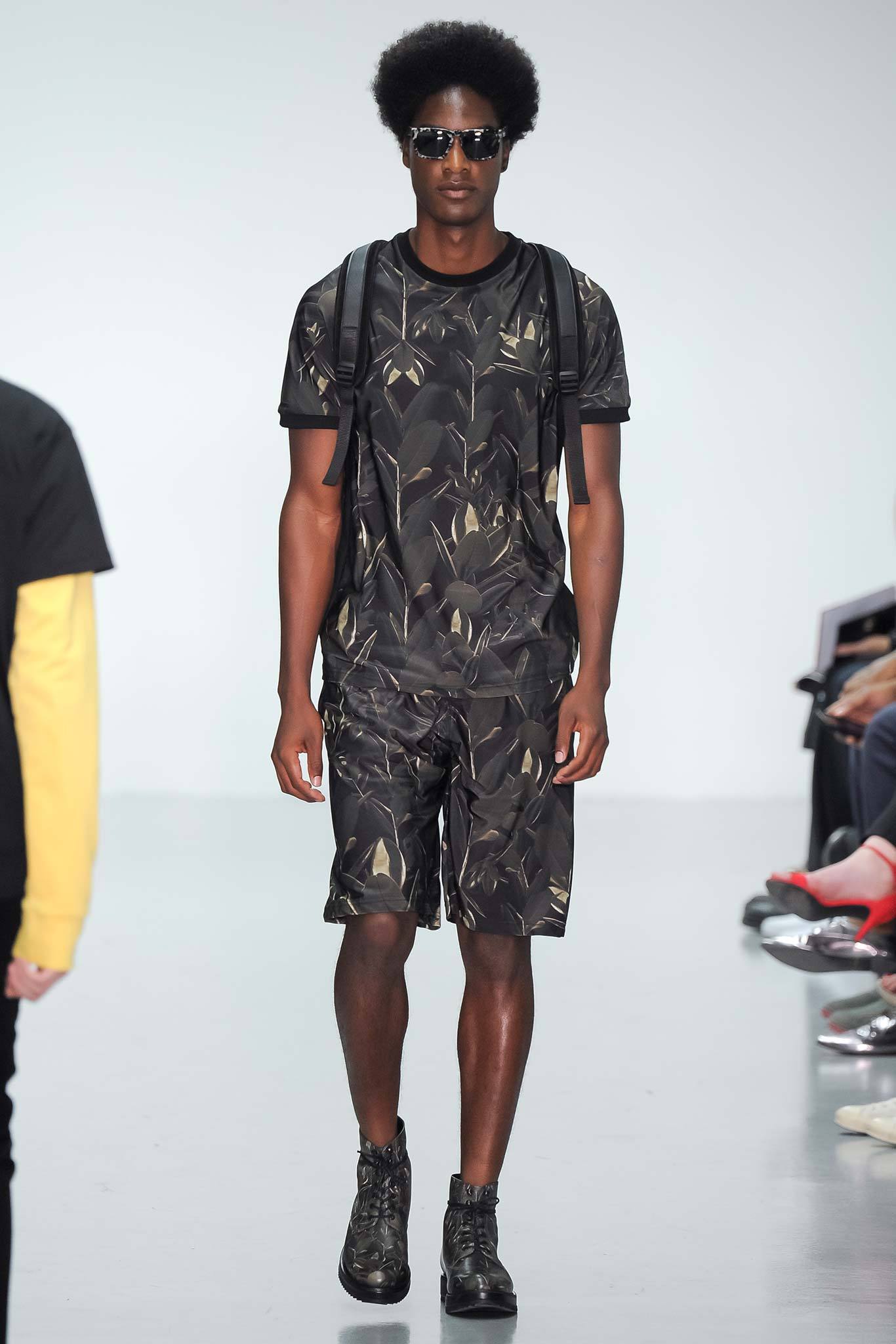 This relaxed ensemble features a short-sleeve t-shirt adorned with a striking multi-colored print, paired with coordinating shorts that echo the vibrant design. The combination creates a cohesive look, emphasizing comfort while making a bold visual statement.