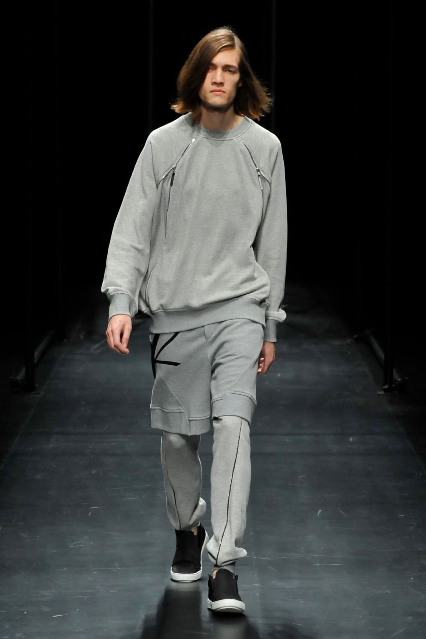 A relaxed gray sweater with long sleeves paired with matching pants featuring zippered details.