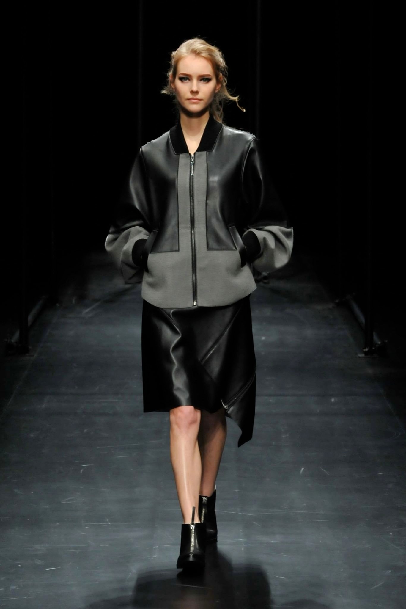 A fitted black leather dress with an asymmetric hem and a zippered long-sleeve jacket.