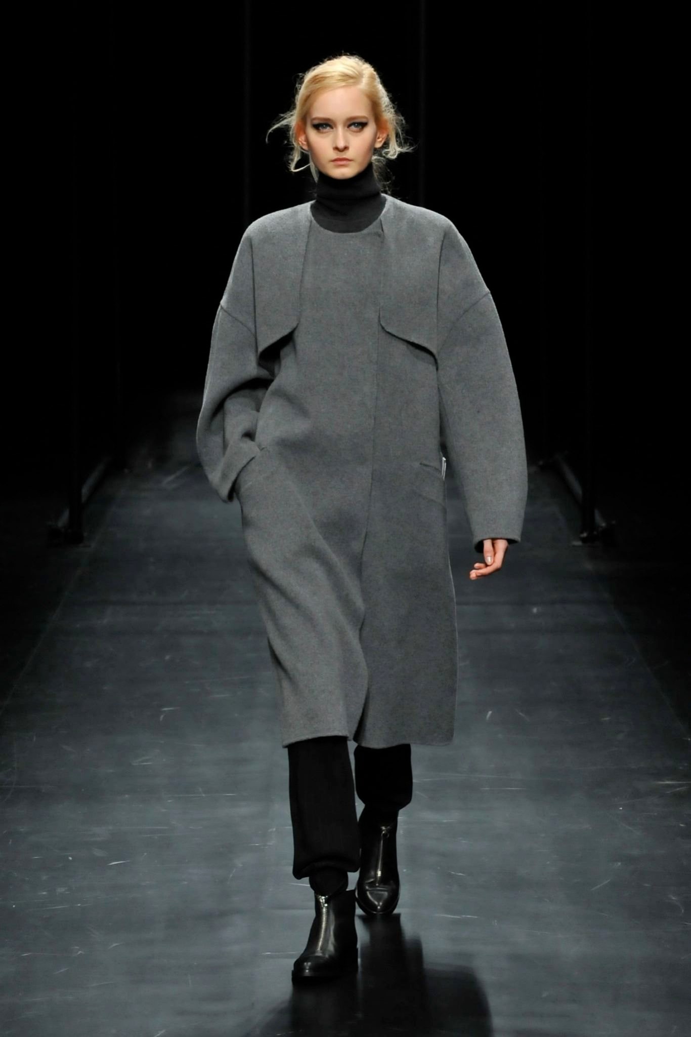 An oversized gray wool coat with long sleeves and an asymmetric design.