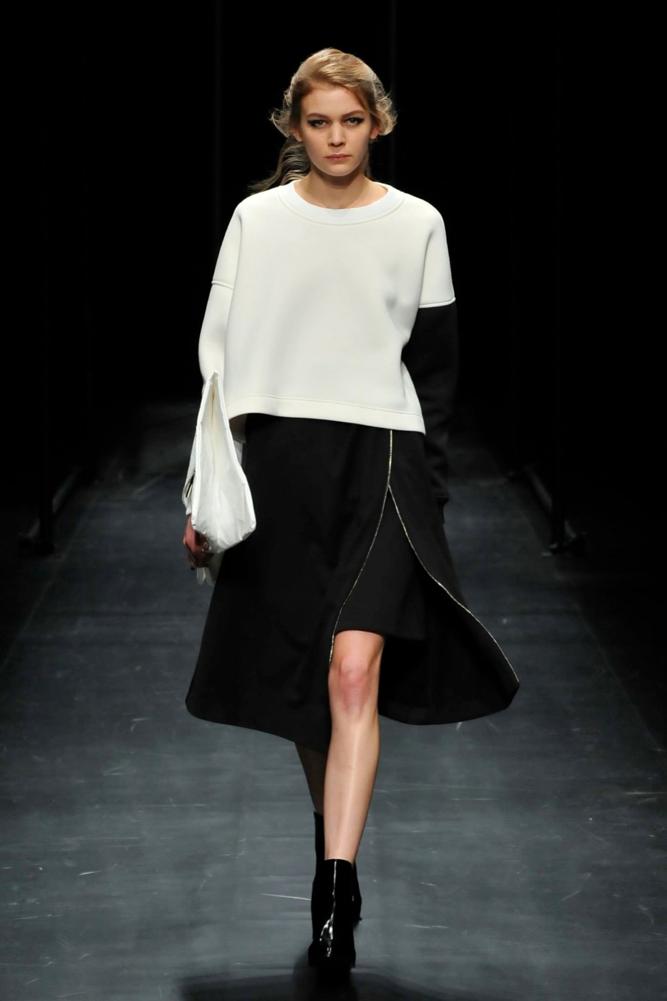 A relaxed black and white long-sleeve top paired with an asymmetric zippered skirt.