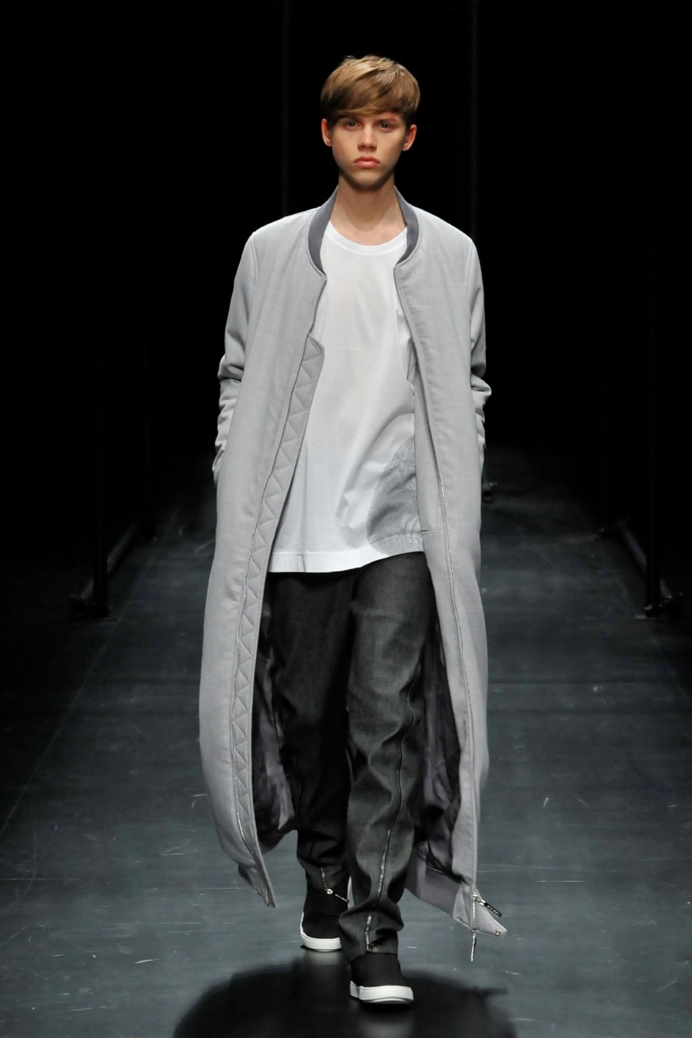 A relaxed gray coat layered over a white shirt, featuring long sleeves and a collared design.