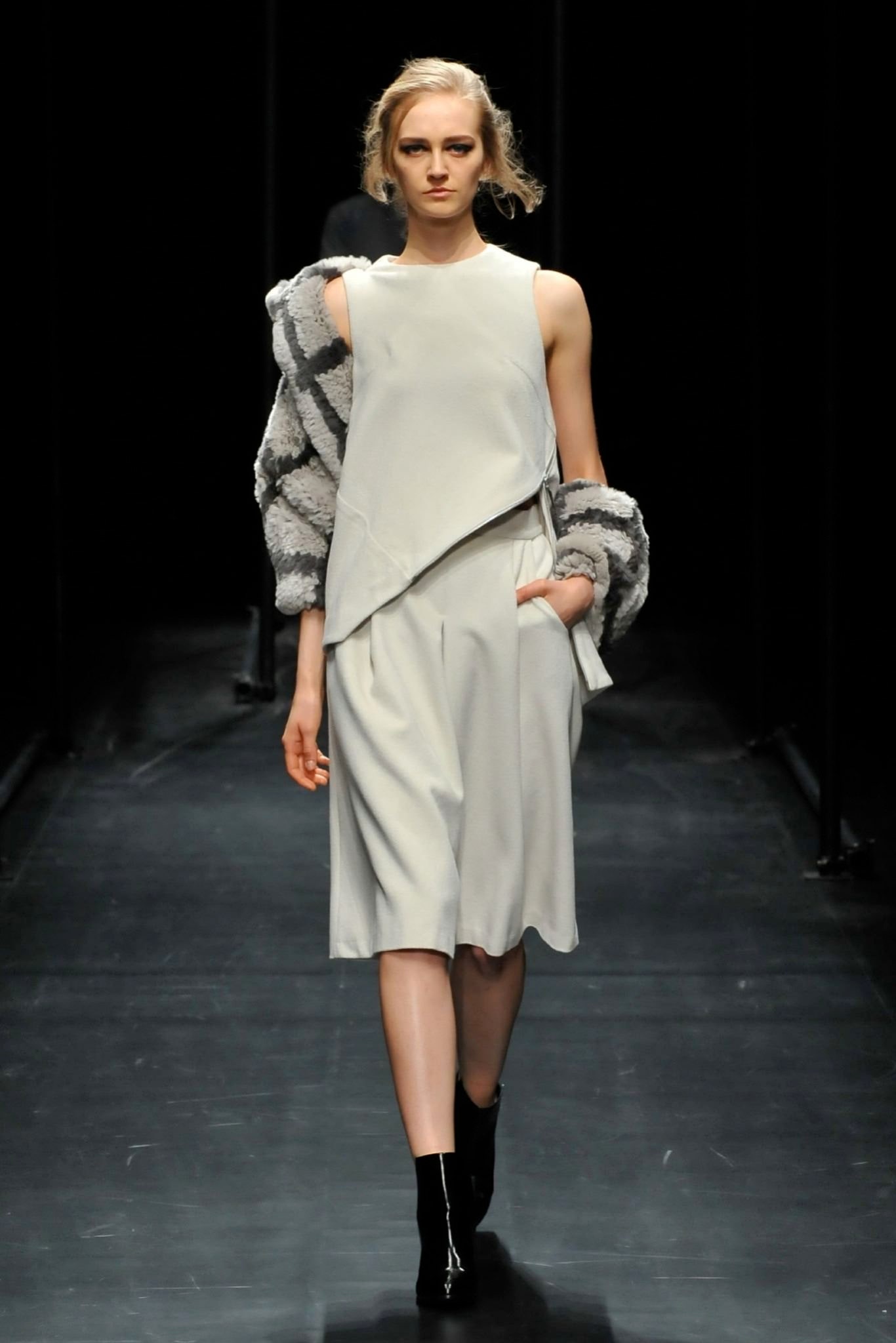 A relaxed gray sleeveless dress with a high neckline and asymmetric design detail.