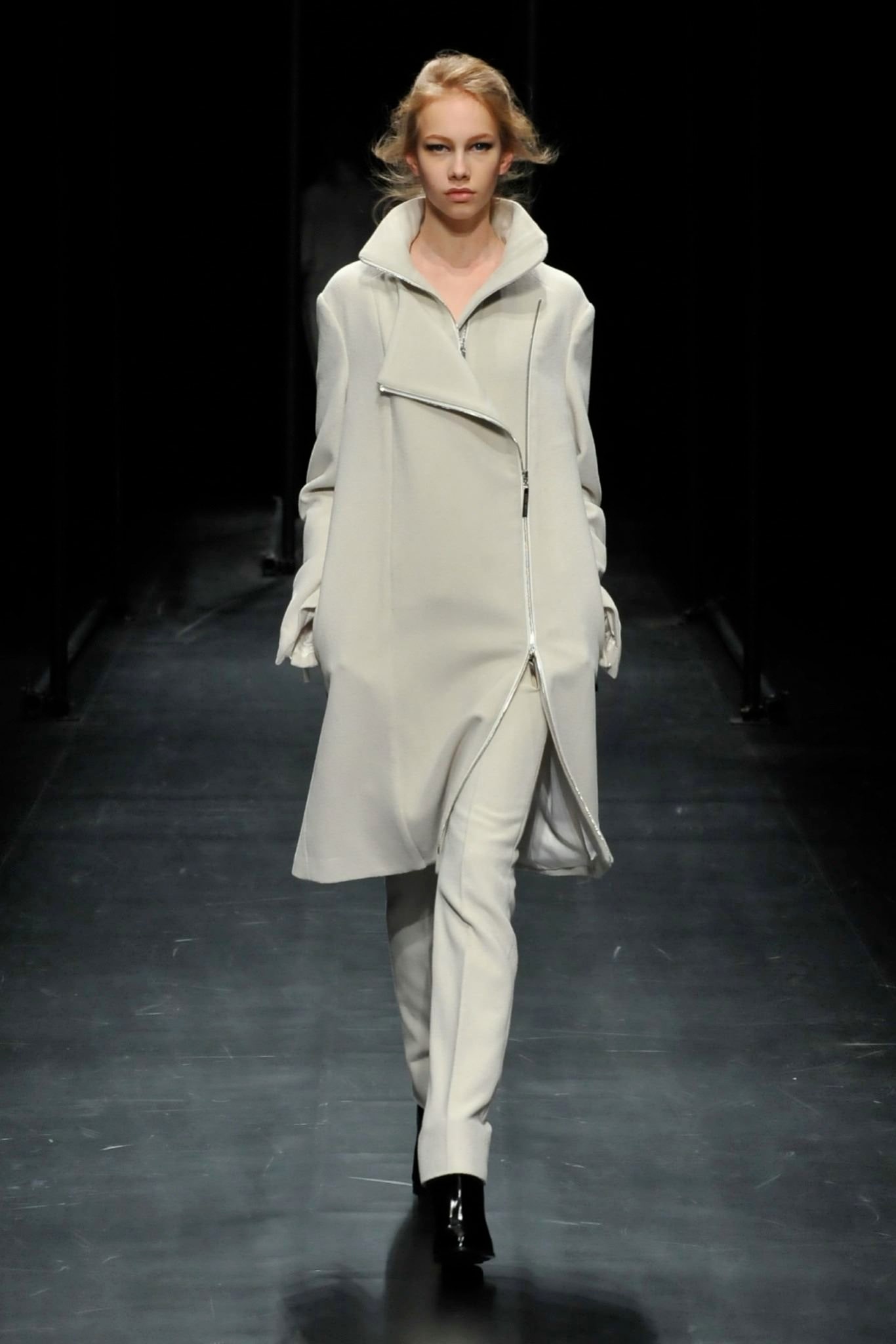 A relaxed white coat with long sleeves and a zippered detail, paired with matching pants.
