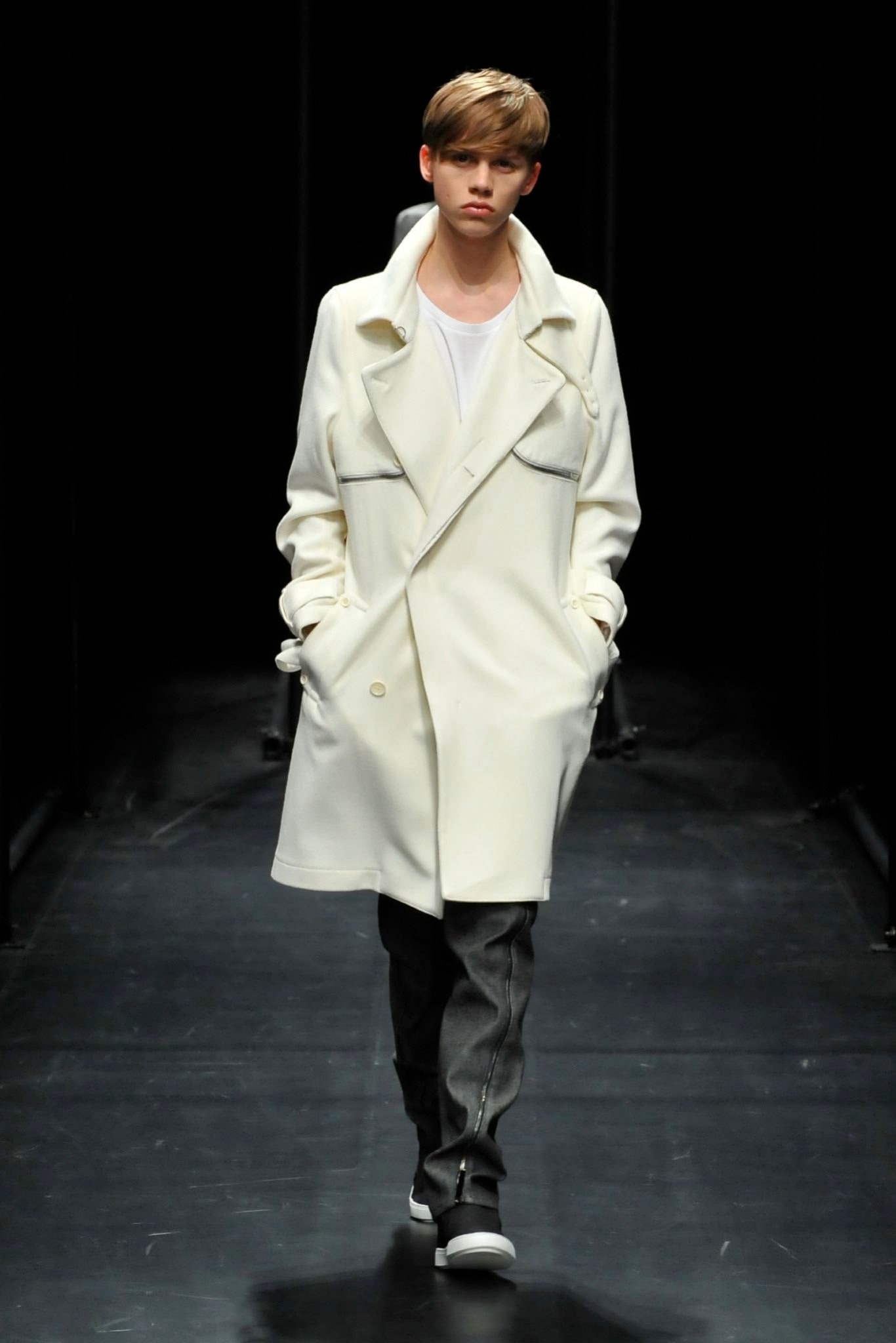 A relaxed white coat paired with gray straight-leg pants, featuring a collared design and buttoned details.