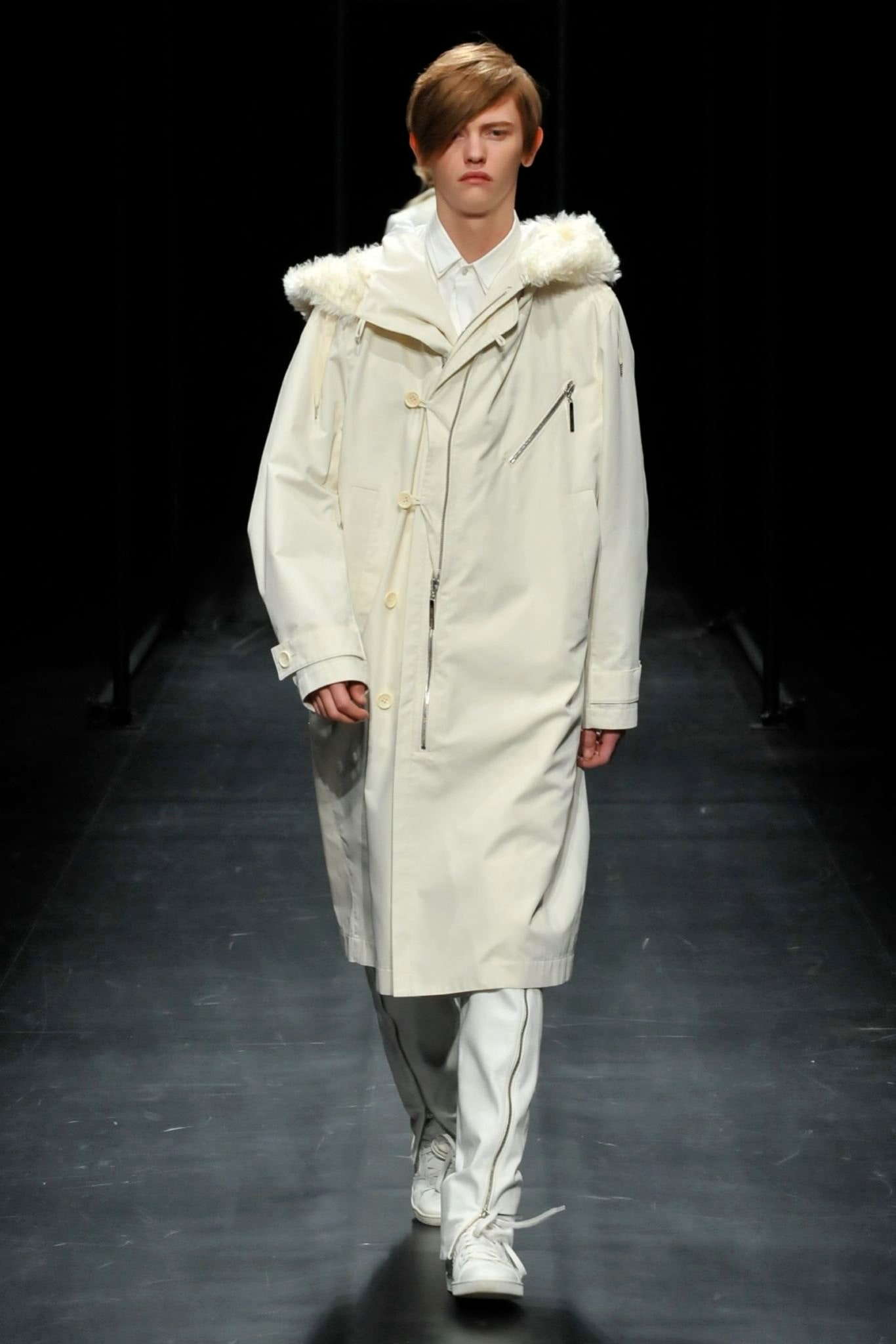 A relaxed white cotton coat with a collared neckline and zippered details.