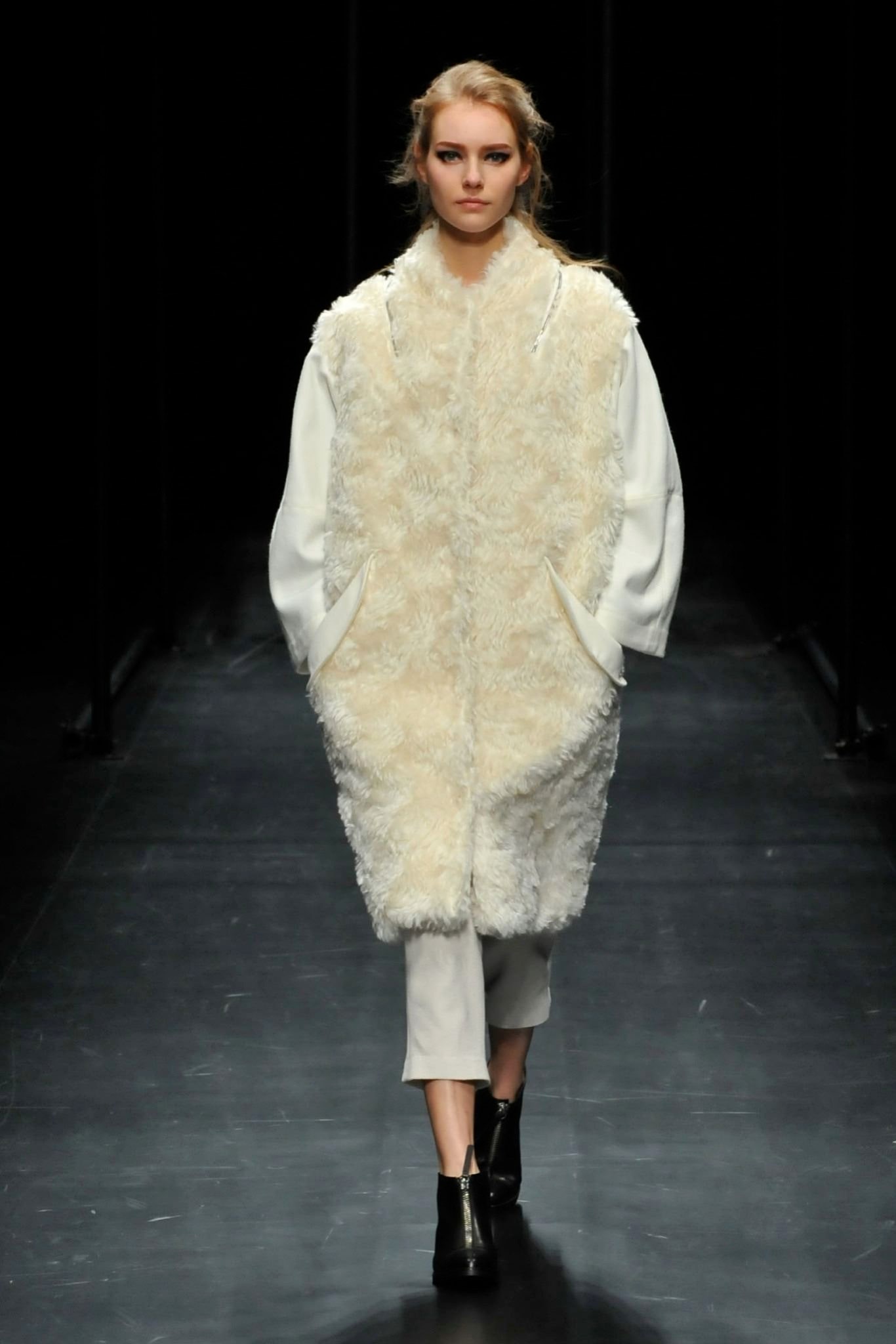 A relaxed white fur coat with long sleeves and a layered design.